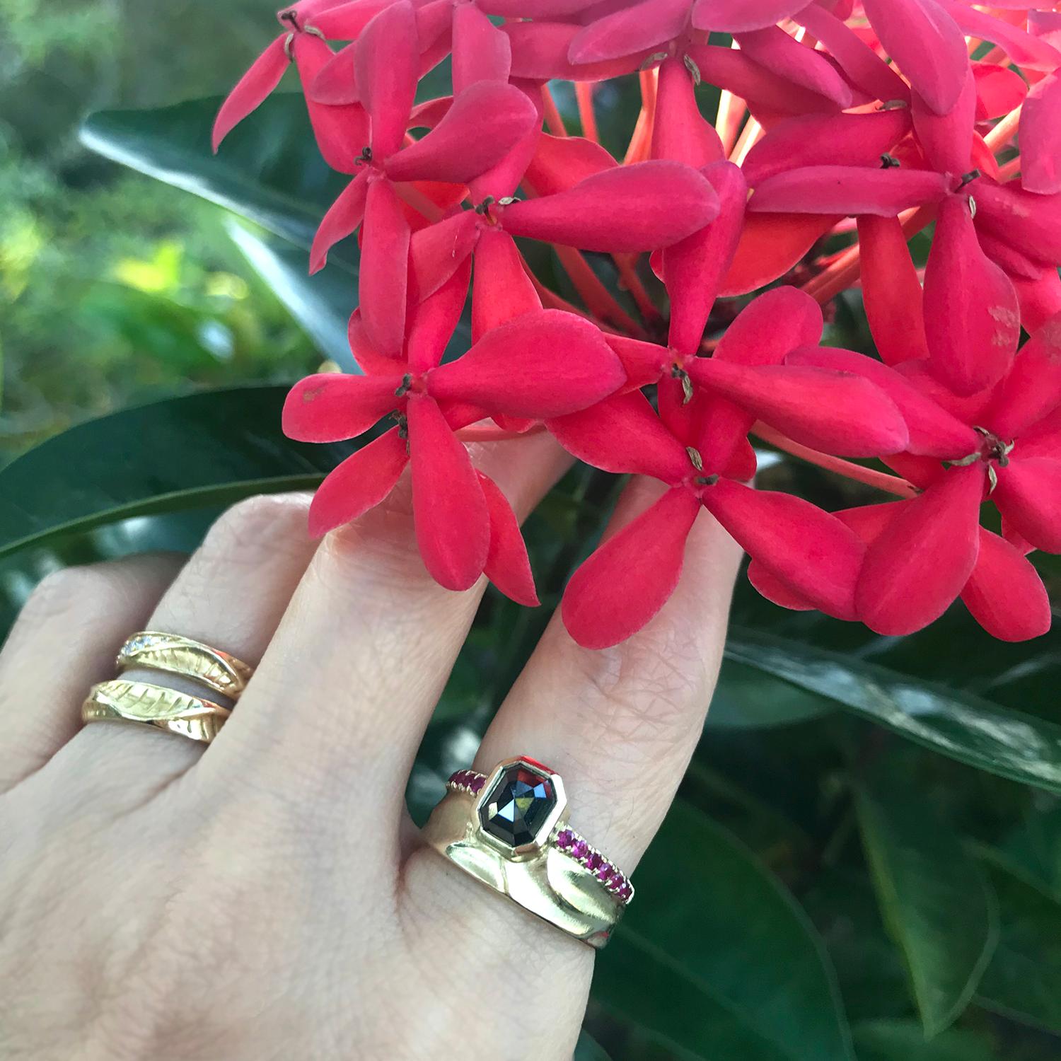 K.Mita's one-of-a-kind 14 Karat Gold Noire Scarletta Ring features a 1.40 Carat Black Diamond accented with 0.28 Carats Pink Sapphires surrounding the edge. The modern ring, with a width that ranges between 8.5 mm and 11 mm, is handmade by the