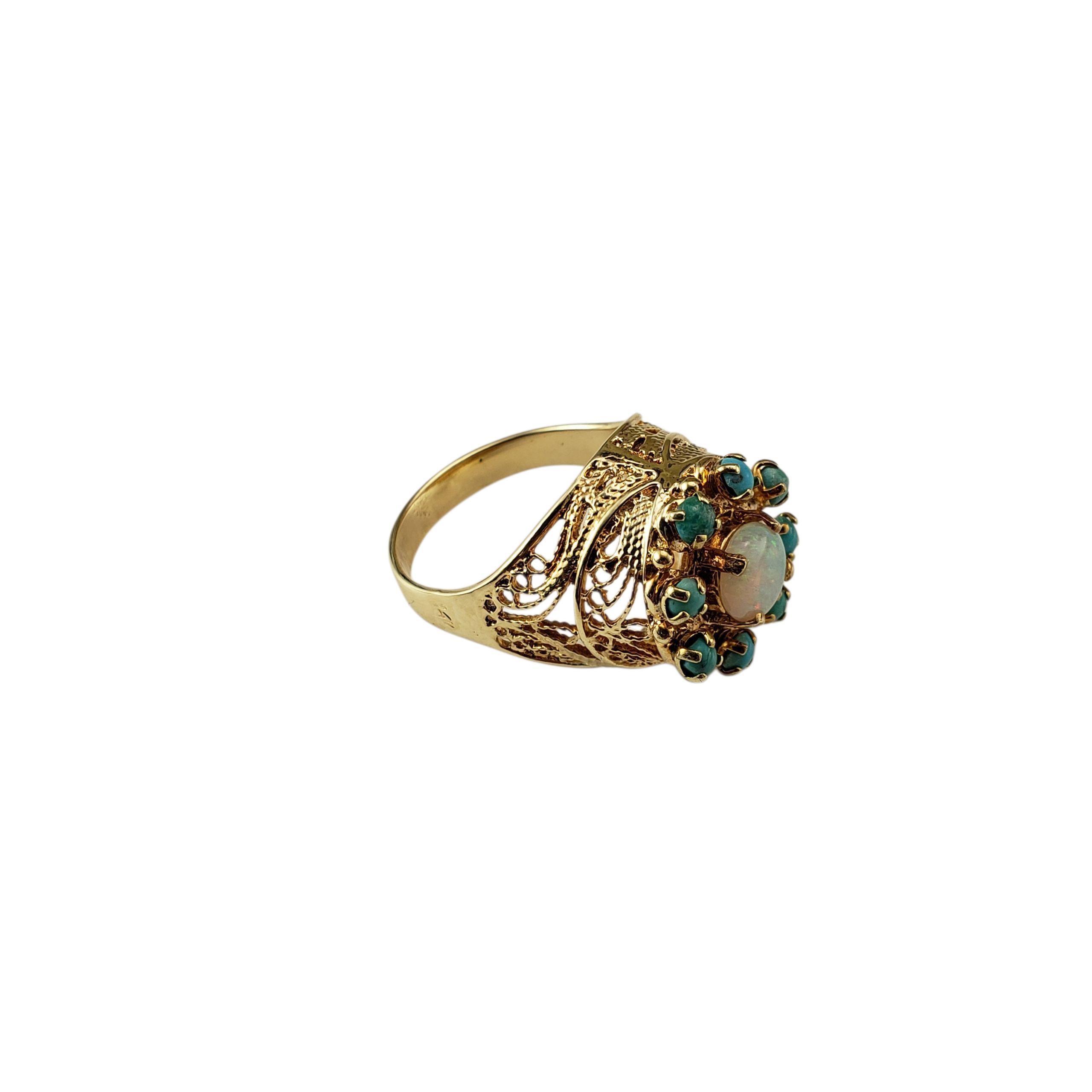 Bague en or jaune 14 carats opale et turquoise Taille 6

Cette bague remarquable présente une opale ronde lumineuse en son centre, entourée de 8 pierres turquoise vibrantes serties dans un filigrane d'or jaune 14K ajouré et joliment détaillé.