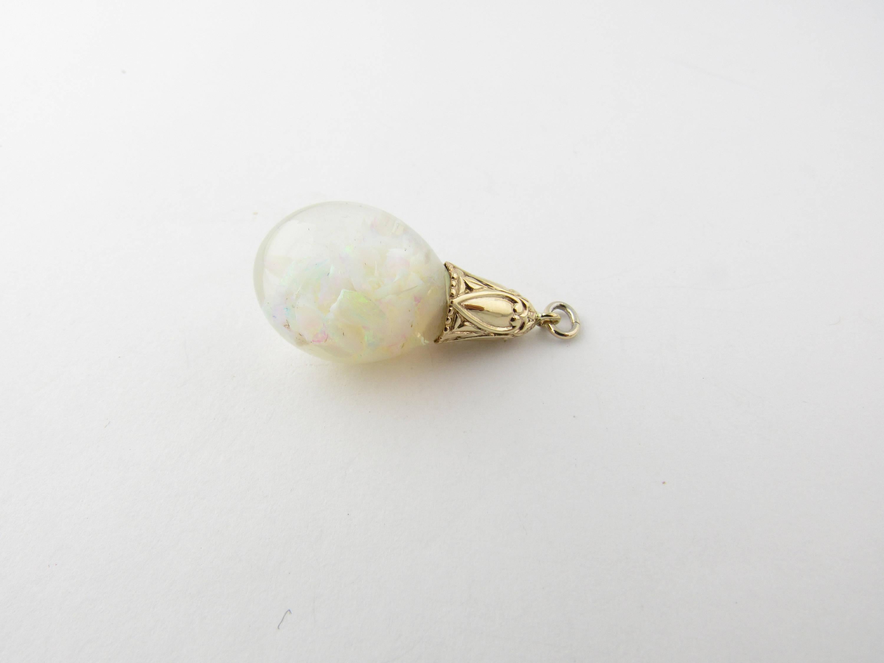 Vintage 14 Karat Yellow Gold Opal Pendant- 
This unique pendant features a glass drop filled with genuine opal chips and held by a beautifully embossed yellow gold setting. 
Size:   30 mm x  14 mm (actual pendant) 
Weight: 2.8 dwt. /   4.5 gr.