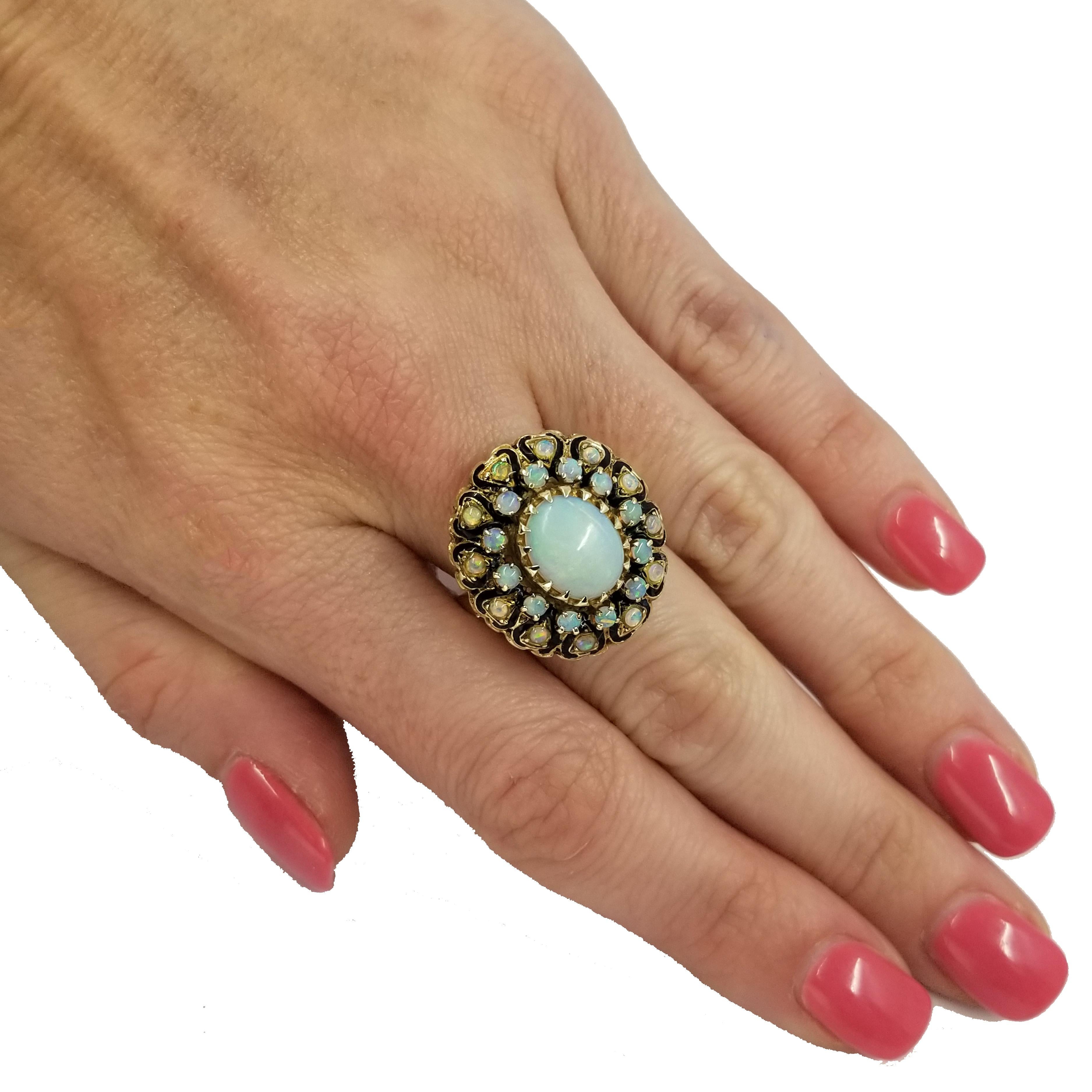 14 Karat Yellow Gold Ring Featuring A Prong Set Oval Opal Surrounded by Two Rows of 24 Prong Set Smaller Round Opals. Opals Have a White Body with Play of Color Phenomenon. Total Carat Weight Is Approximately 3 Carats. The Ring Is Designed with a