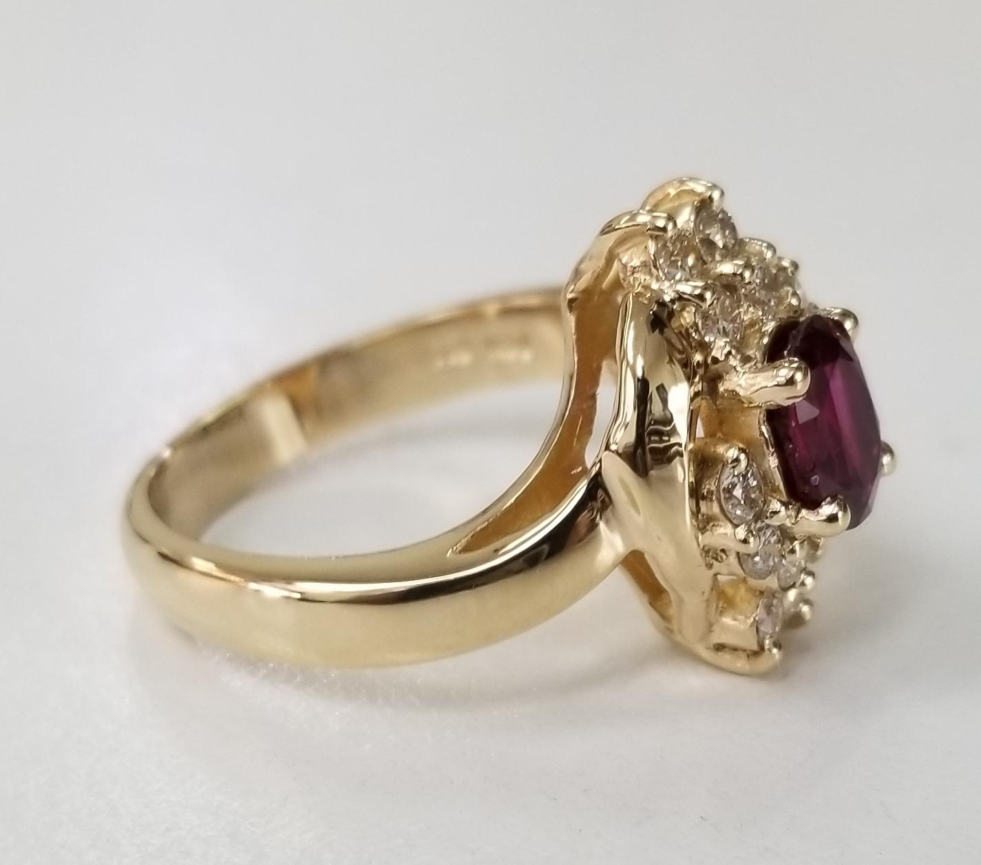 14 Karat Gelbgold, ovaler Rubin-Diamant-Ring, mit 1 ovalen Rubin von Edelsteinqualität mit einem Gewicht von 1,15cts, umgeben von 10 runden Diamanten im Vollschliff von feiner Qualität mit einem Gewicht von .42pts.  Dieser Ring ist eine Größe 6,