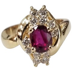Anillo de oro amarillo de 14 quilates con diamante y rubí ovalado