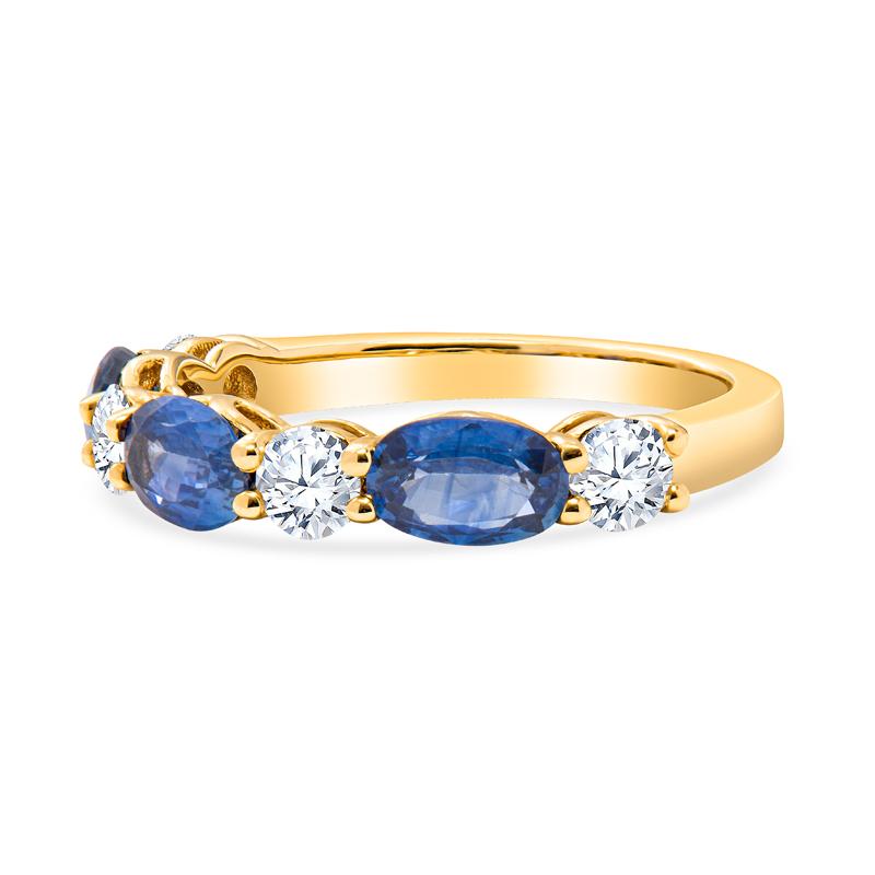 This 14 karat yellow gold band features 1.56 carat total weight in oval shaped natural blue sapphires alternating with 0.58 carat total weight in round diamonds set in 14 karat yellow gold. It is a size 6.5 but can be resized upon request.
