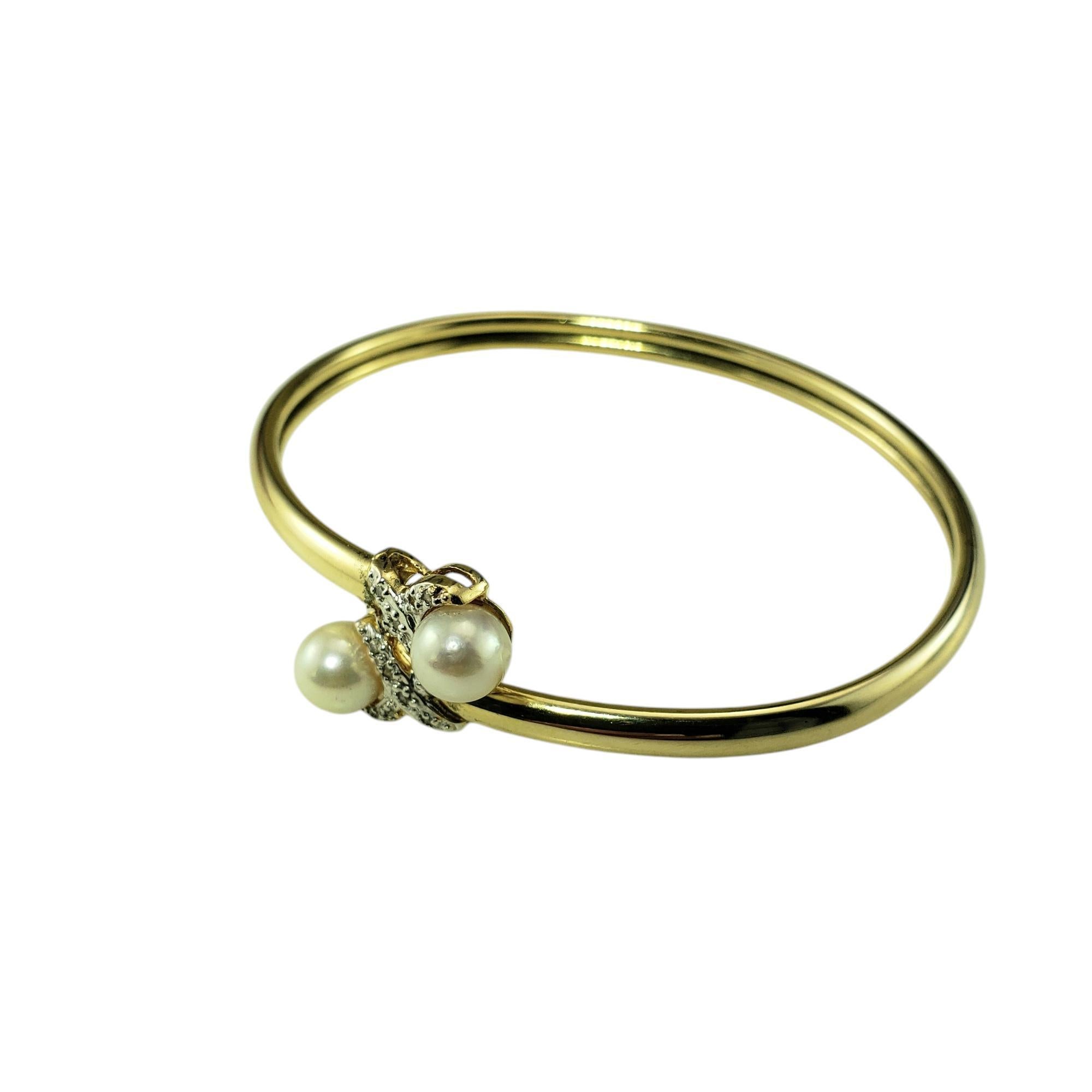14 Karat Yellow Gold Pearl and Diamond Bangle Bracelet-

This lovely flexible bangle bracelet features two white pearls (7 mm each) and 14 round single cut diamonds set in polished 14K yellow gold.

Width at front: 16 mm. Bracelet width: 4