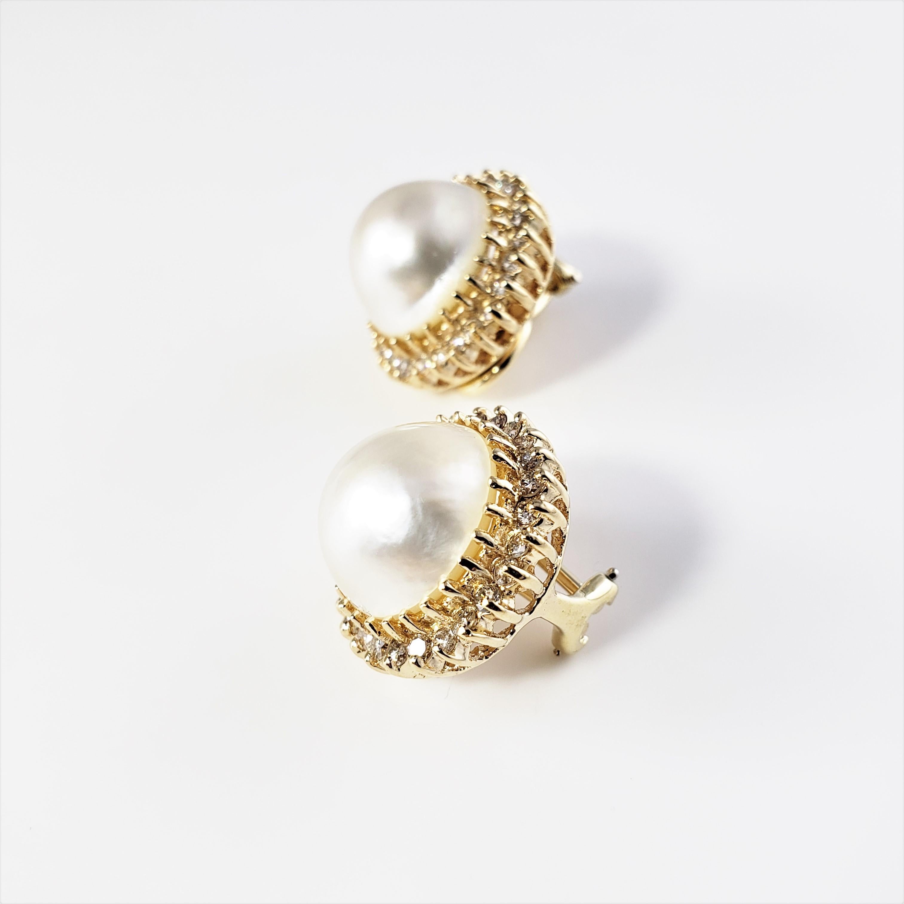 14 Karat Yellow Gold Pearl and Diamond Clip On Earrings-

These stunning earrings each feature one 13 mm pearl surrounded by 26 round brilliant cut diamonds set in classic 14K yellow gold.  Hinged clip on closures.

Approximate total diamond weight: