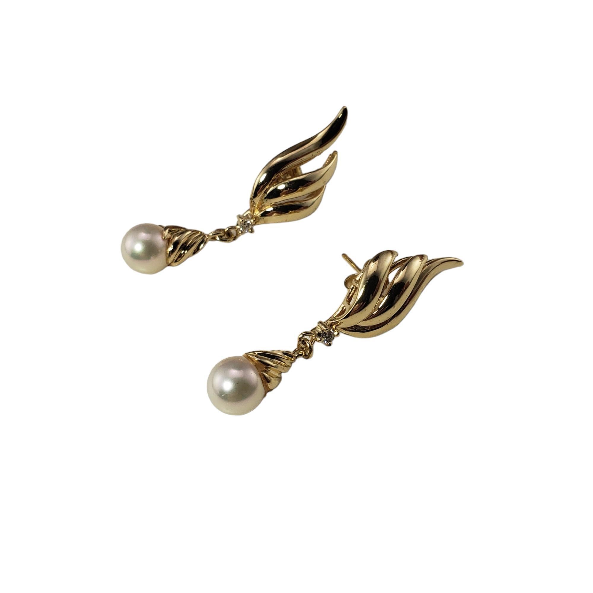 Vintage 14 Karat Yellow Gold Pearl and Diamond Earrings-

These elegant dangle earrings each feature one white pearl (7 mm) and one round brilliant cut diamond set in classic 14K yellow gold.  Push back closures.

Approximate total diamond weight: 