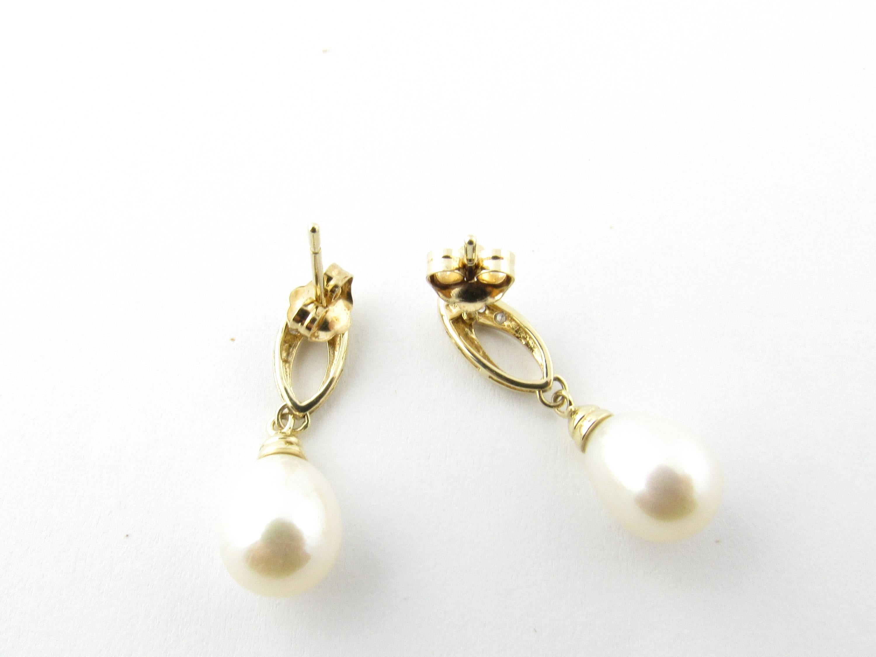Vintage 14 Karat Yellow Gold Pearl and Diamond Earrings- 
These lovely dangling earrings each feature one teardrop pearl (8 mm each) accented with three round brilliant cut diamonds and set in 14K yellow gold. 
Approximate total diamond weight: .05