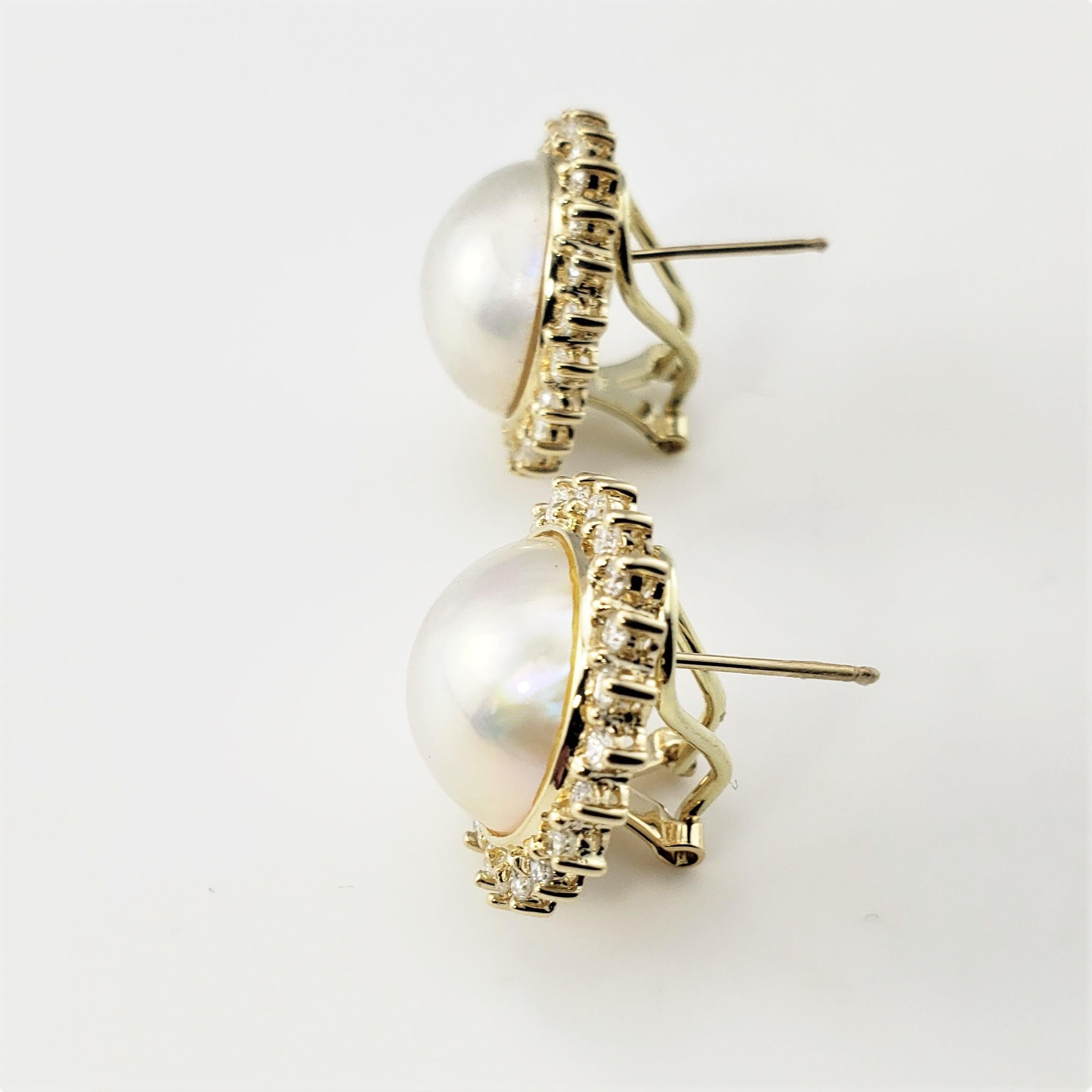 14 Karat Yellow Gold Pearl and Diamond Earrings-

These lovely earrings each feature one round white pearl (13 mm) surrounded by 22 round brilliant cut diamonds.  Hinged closures.

Approximate total diamond weight:  .88 ct.

Diamond color: 