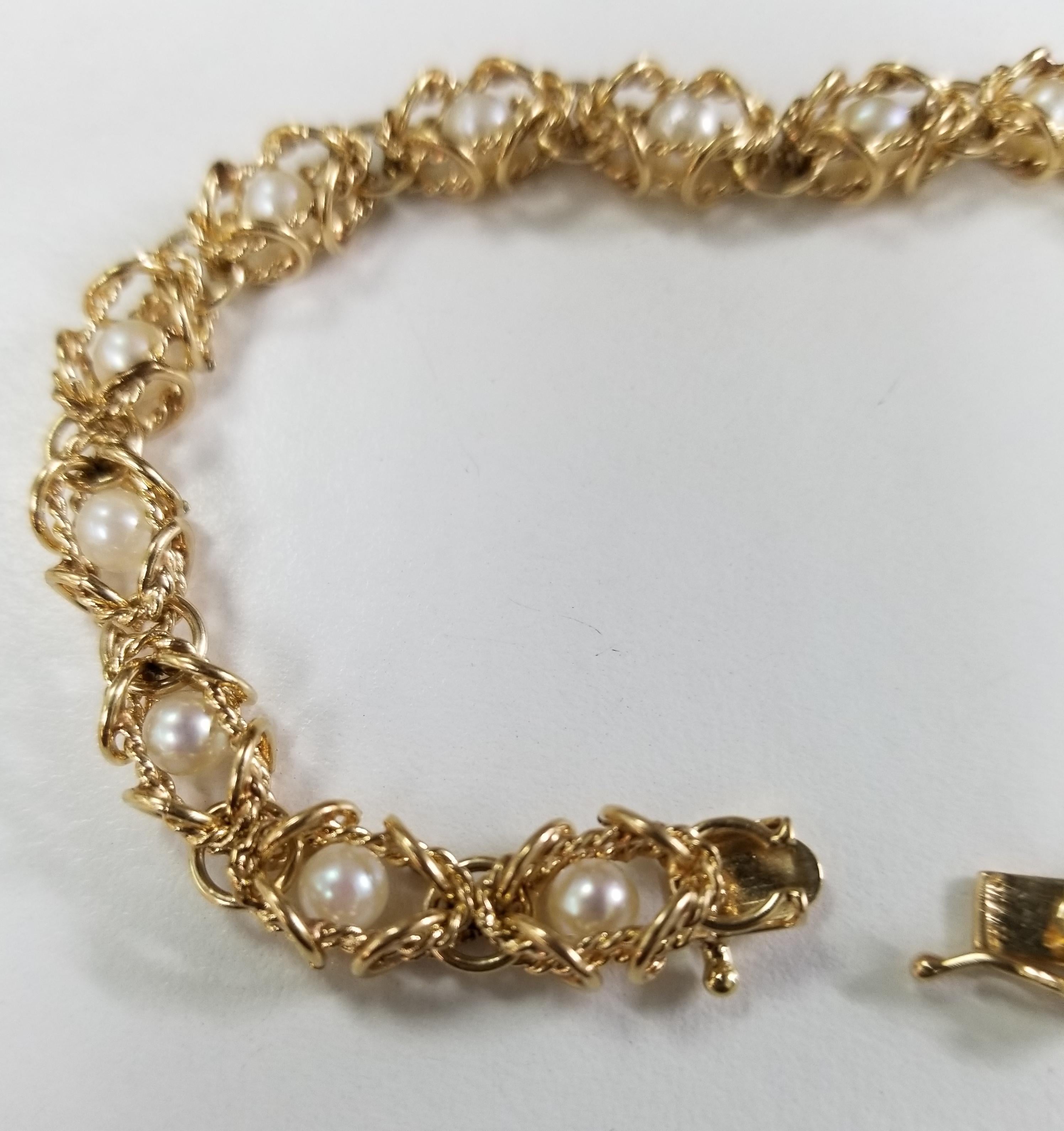 14 karat yellow gold pearl bracelet containing 15 4.5mm round pearls in a cage, length is 7 3/4 inches.