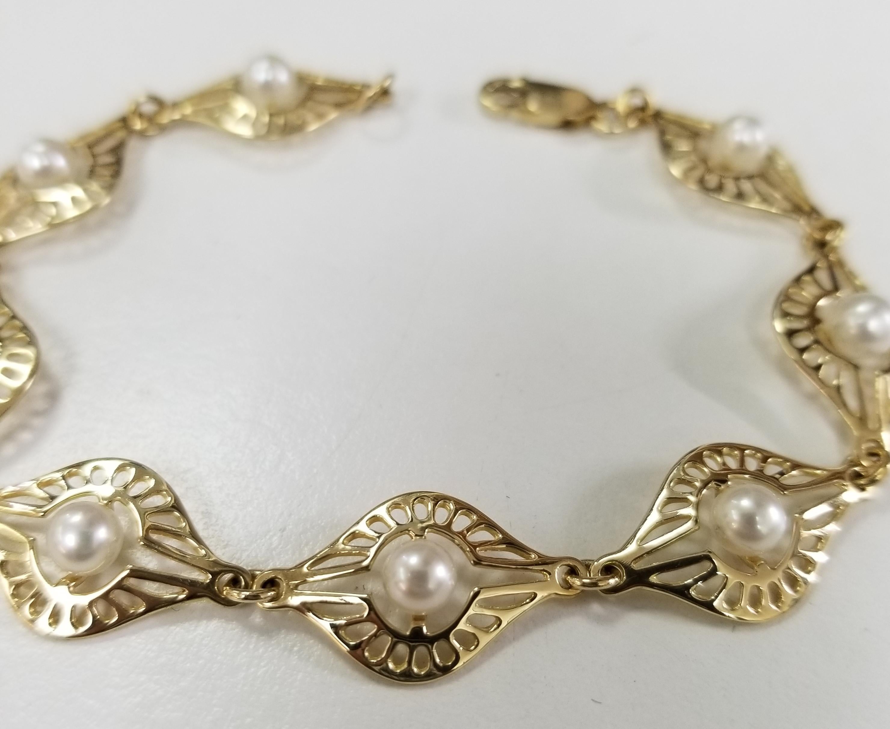 14 karat yellow gold pearl bracelet containing 8 5mm pearls, length of bracelet 7 1/2 inches.