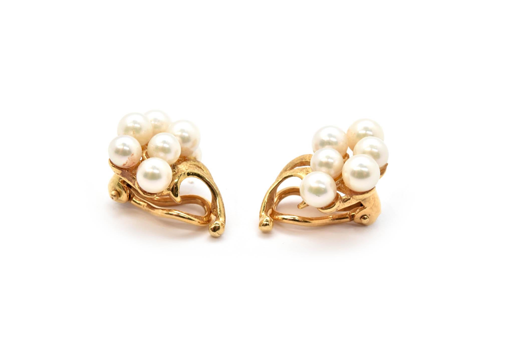 These earrings are made in 14k yellow gold. Each earring features a cluster of seven pearls ranging from 4.2-5mm. This lovely pair measures 19x17mm, and are completed with omega clip-on backs. Together the pair weighs 7.29 grams. 