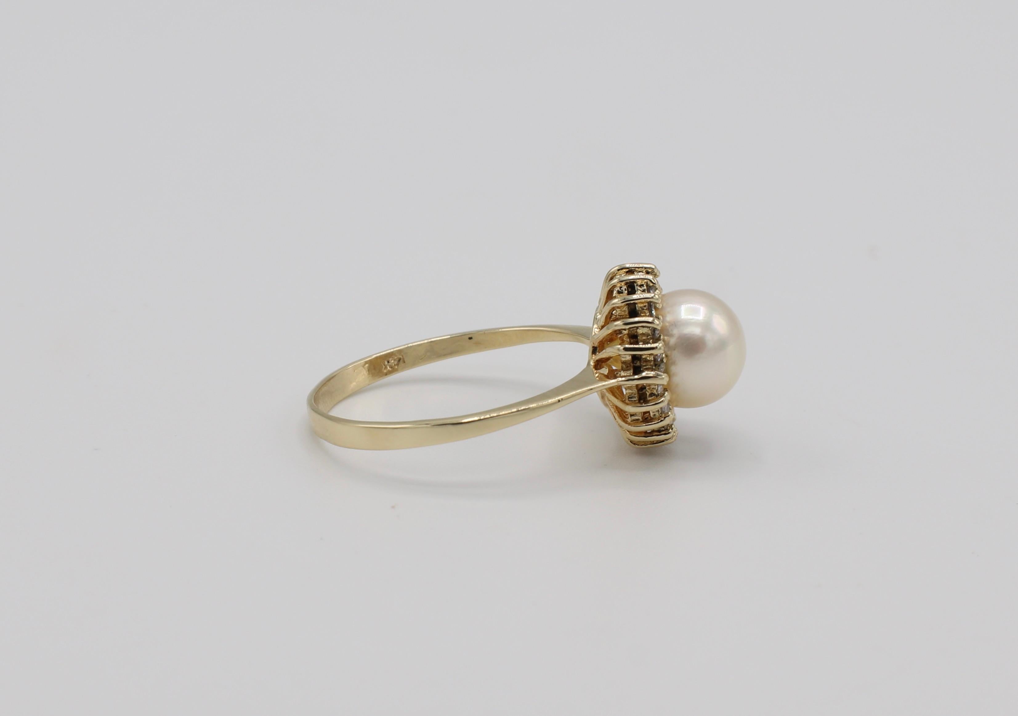 14 Karat Yellow Gold Pearl & Diamond Halo Cocktail Ring Size 7
Metal: 14k yellow gold
Weight: 2.63 grams
Pearl: 7MM, white cultured pearl, creamy luster
Diamonds: .10 CTW I SI 
Top of ring measures 11MM diameter 
Band is 1.6MM wide at base 
Size 7