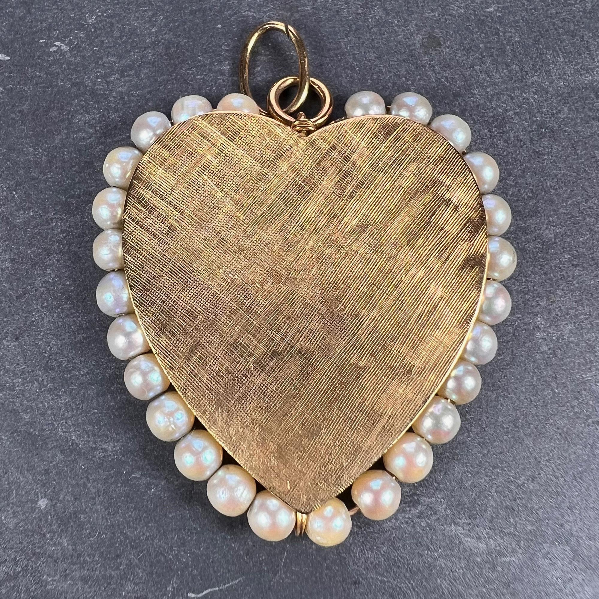 A 14 karat (14K) yellow gold charm pendant designed as a very large love heart, engraved with a cross-hatch pattern to one side, polished to the other. The heart is surrounded by 26 white cultured pearls with an average diameter of 4mm. Stamped 14K