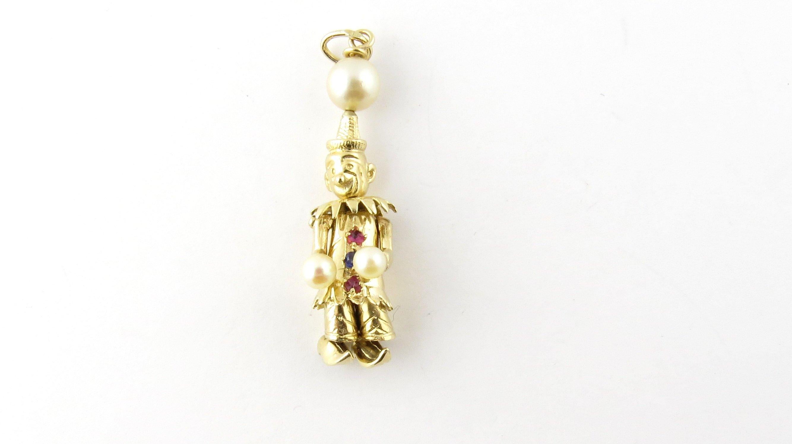 Vintage 14 Karat Yellow Gold Pearl, Ruby and Sapphire Articulated Clown Pendant- 
This stunning pendant features a 3D articulated clown with moving arms, head and legs. Accented with two 4 mm pearls, one 7 mm pearl, two rubies and one sapphire.