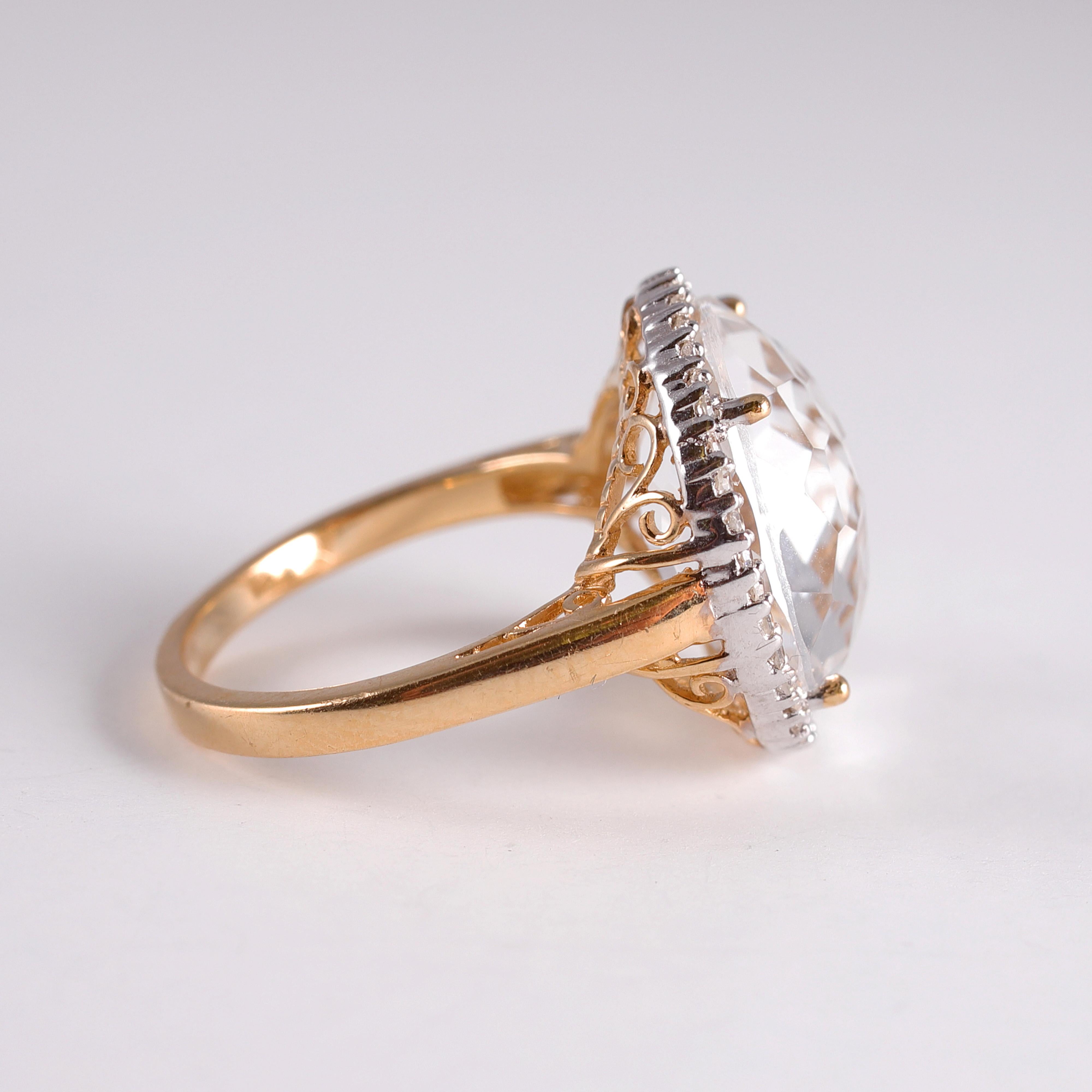 What a great fashion statement!  This fun colorless quartz ring is in 14 karat yellow gold and is accented with diamond trim.  The center quartz measures approximately 15.00 mm. Size 6 1/2.