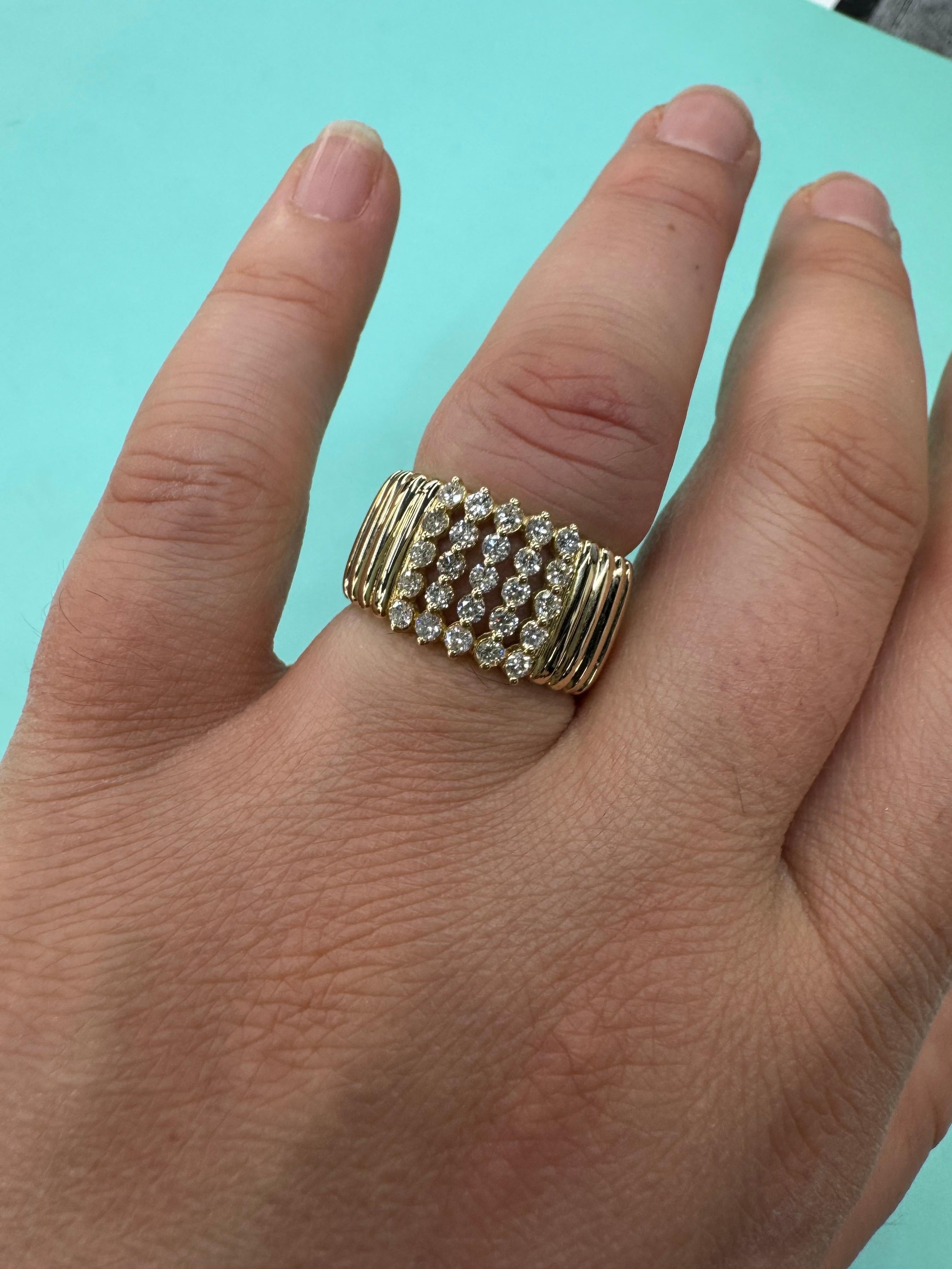Questo bellissimo anello in oro giallo 14 carati presenta 25 diamanti per un peso totale di 0,76 carati. I diamanti sono di qualità G-SI, pesano 5 grammi e hanno dimensioni pari a 7.
Il design presenta un'ampia fascia con una texture a coste, che
