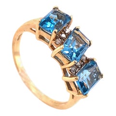 Bague en or jaune 14 carats avec trois topazes bleues taille princesse et détails en diamants