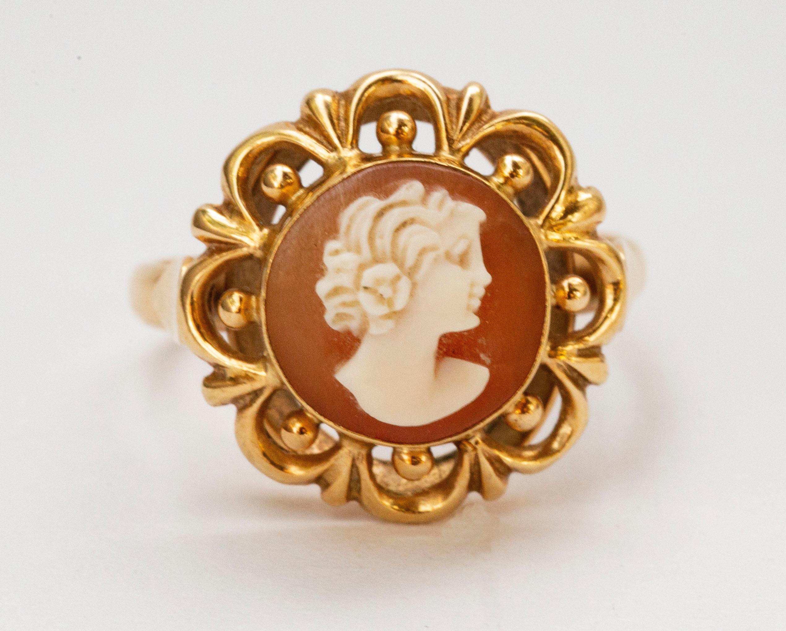 A vintage (ca. 1950s / 1960s) 14 karat solid yellow gold ring with a shell cameo featuring a female silhouette decorated with as openwork edge. The ring is marked with 585 that stands for the 14 karat gold content, and it tested positive for the 14