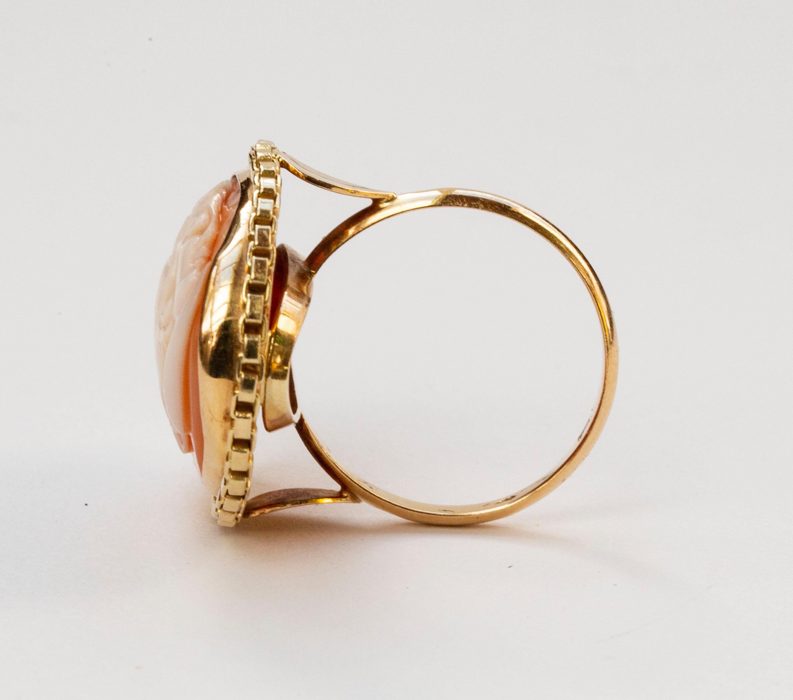 A vintage (ca. 1950s / 1960s) 14 karat solid yellow gold ring with a shell cameo featuring a female silhouette decorated with as openwork chain edge. The ring is marked with 585 that stands for the 14 karat gold content, and it tested positive for