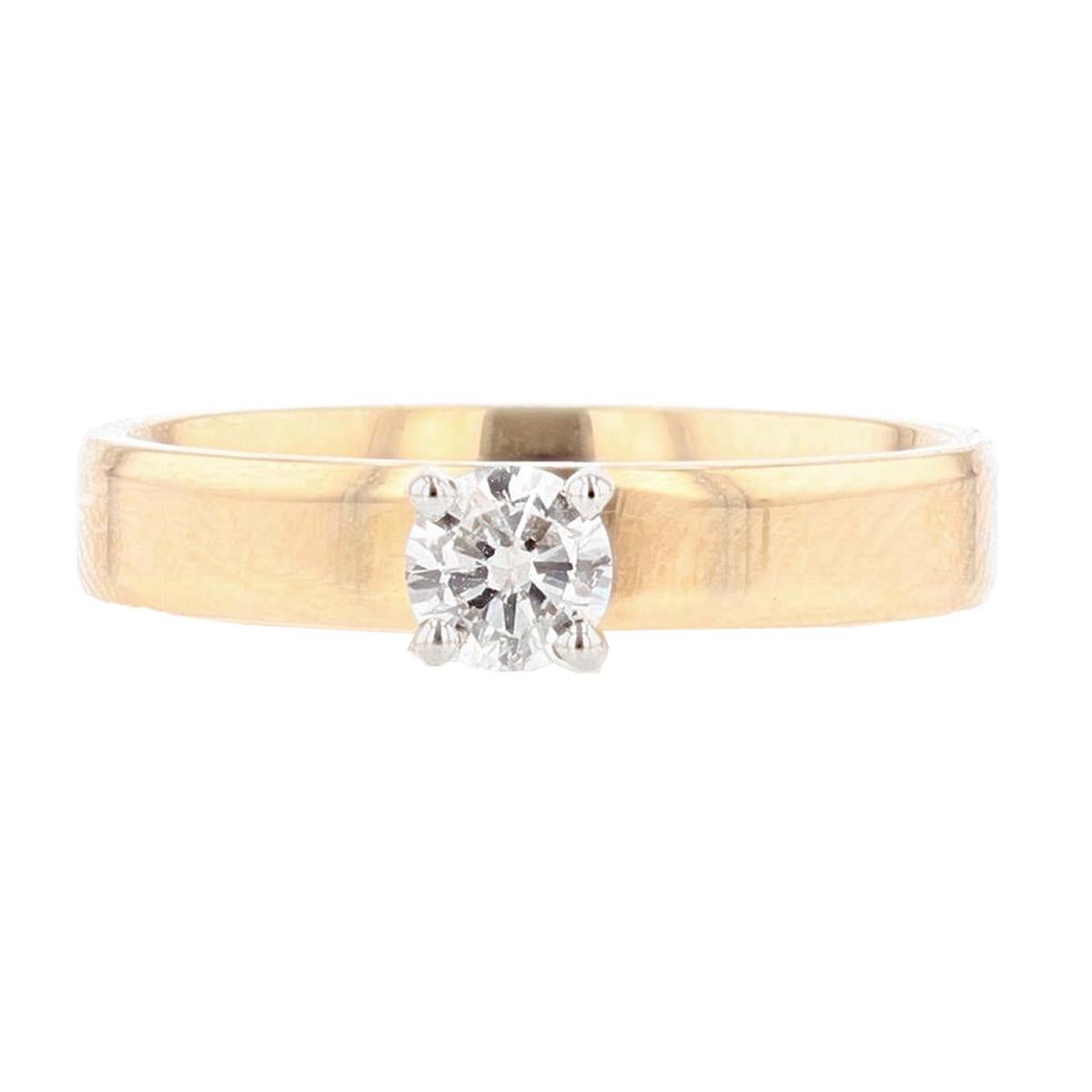 This ring is made with 14 karat yellow and white gold and features one round cut, prong set diamond weighing 0.22ct with a color grade (I) and clarity grade (I1). 