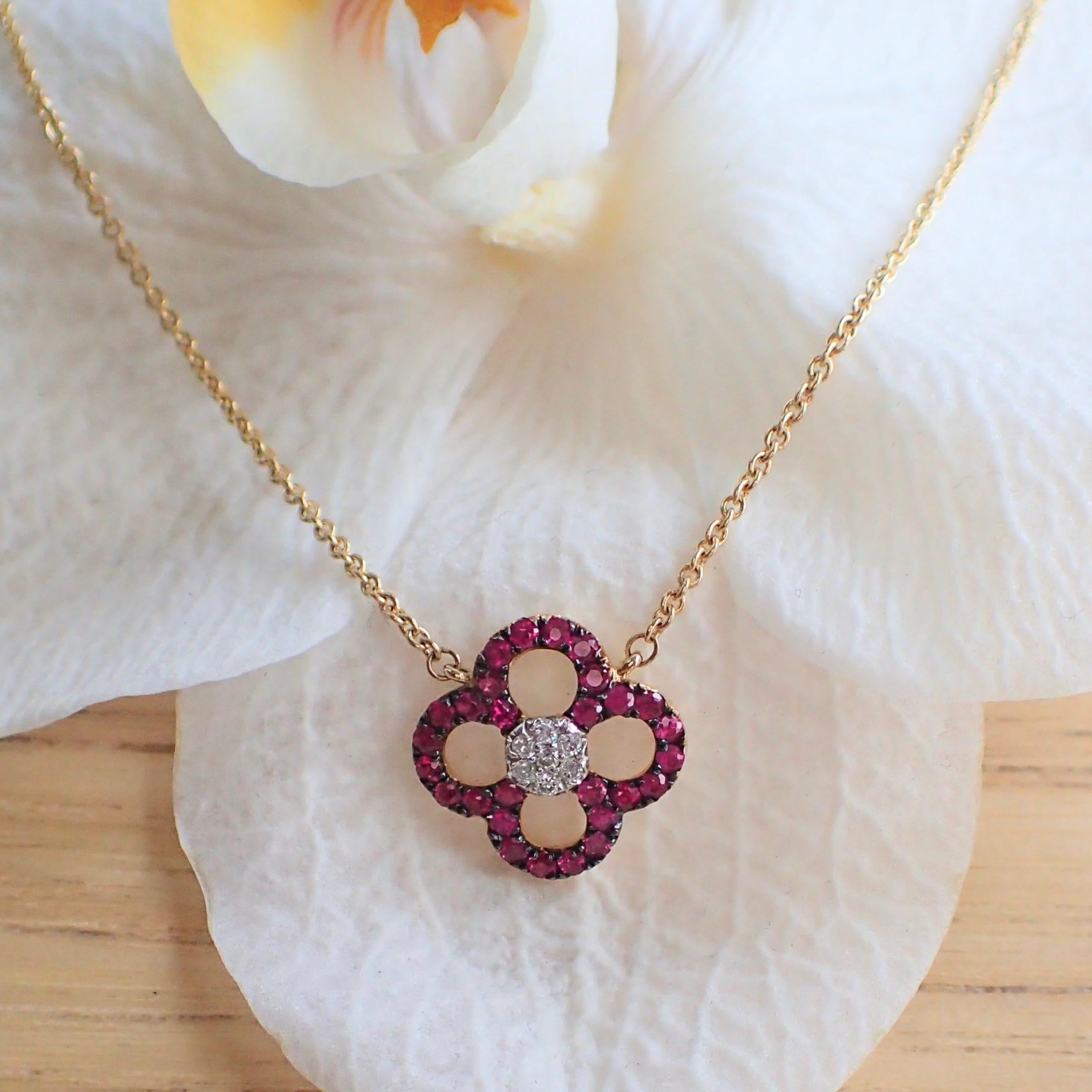 14k yellow gold ruby and diamond flower pendant hangs from a 16” 1.3mm cable chain. The necklace is set with twenty-eight (28) Round Brilliant Cut rubies with Clarity Grade VS-SI and seven (7) Round Brilliant Cut diamonds with Clarity Grade VS-SI