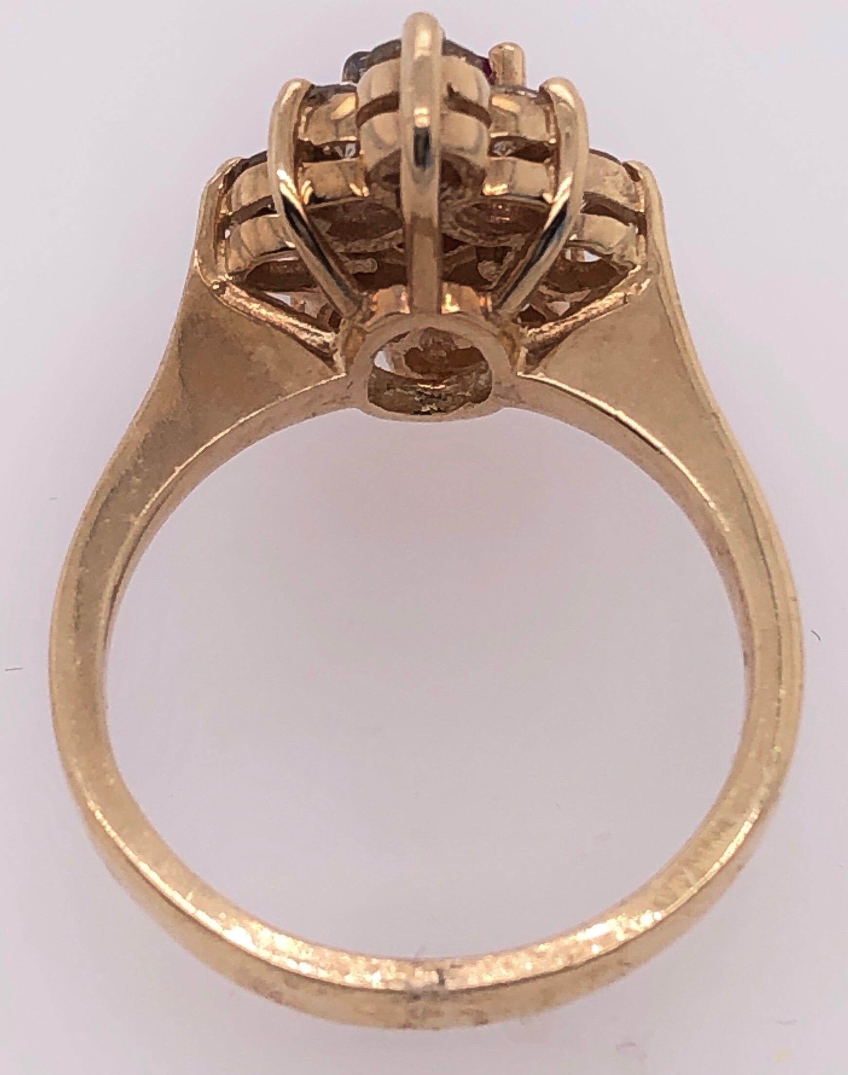 Anillo de oro amarillo de 14 quilates con centro de rubí enmarcado en diamantes en venta 1