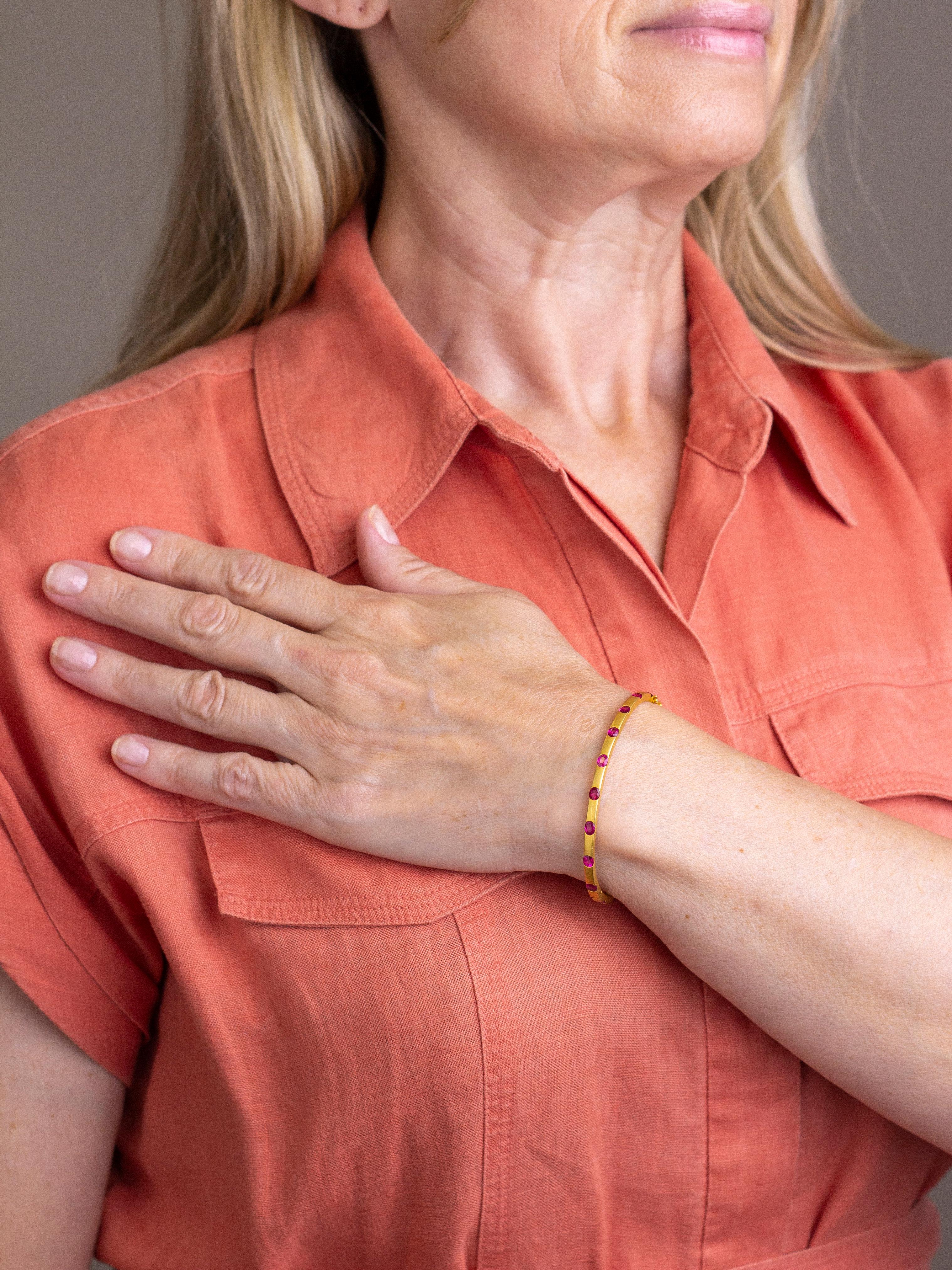 Ce bracelet en or brossé merveilleusement élégant est serti de rubis rouges étonnants. Le bracelet articulé présente la plus belle texture brossée, que l'on pourrait qualifier de 