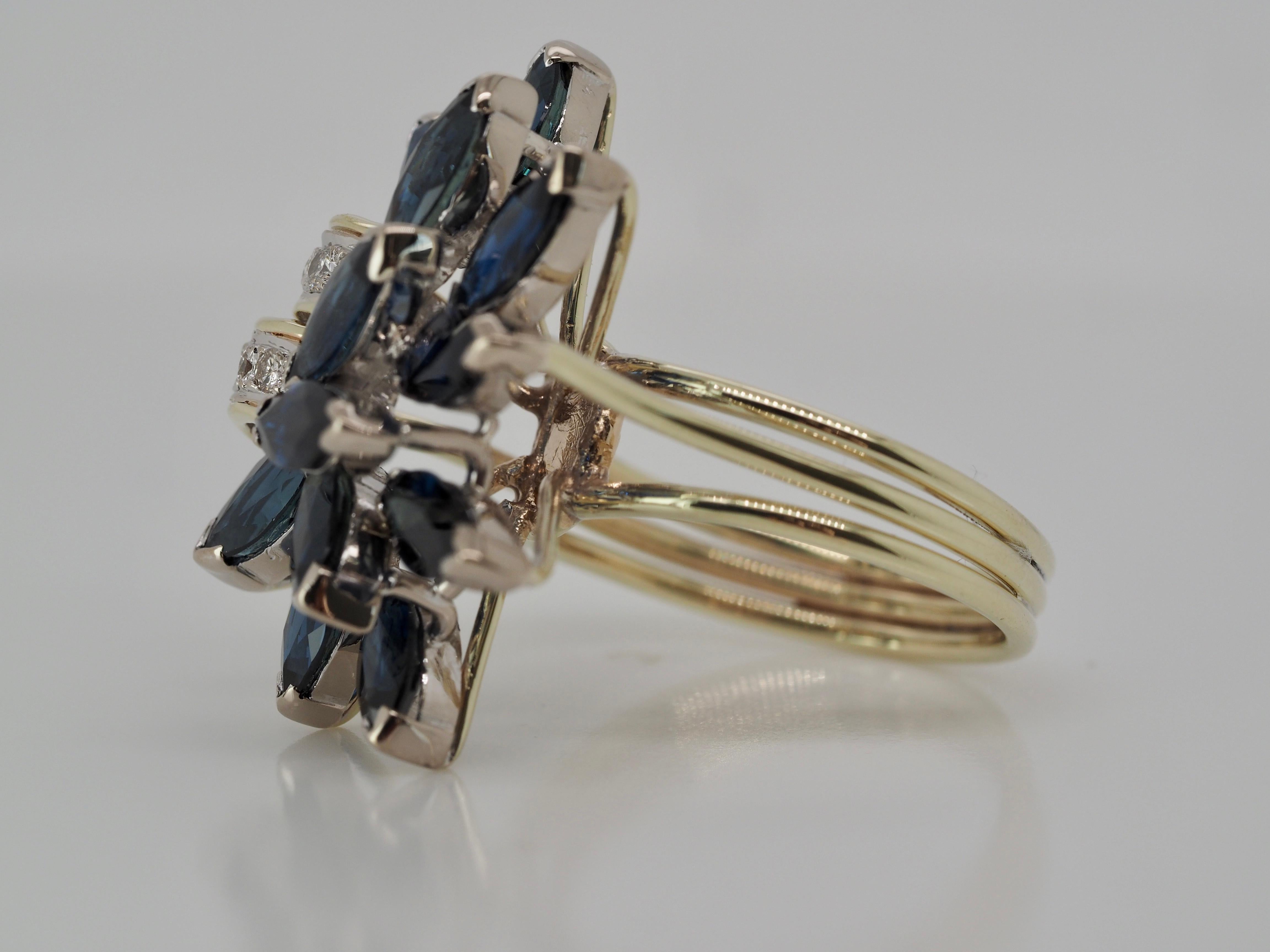 This beautiful ring is a sprinkle of spring time, a statement piece for one's collection. It has beautiful marquise cut sapphire's that shape into a half flower, that came together into a ribbon with stunning round diamonds. This ring is in amazing