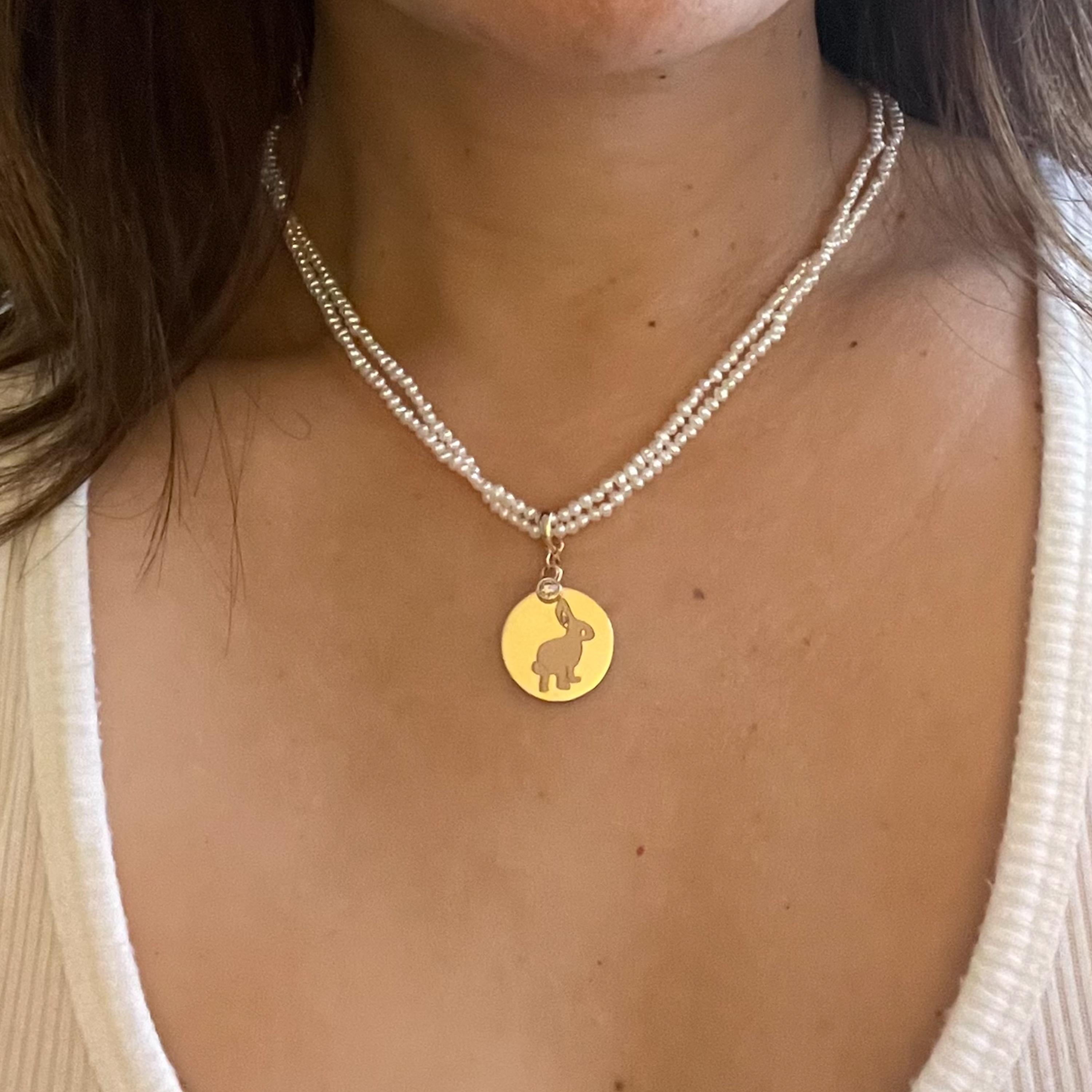 This is a new contemporary pearl necklace with a removable gold pendant, that can be worn two ways.
The beloved Bunny design element is engraved on a gold disc with a diamond charm and hangs off of two rows of SeedPearls.

Depending on your mood,