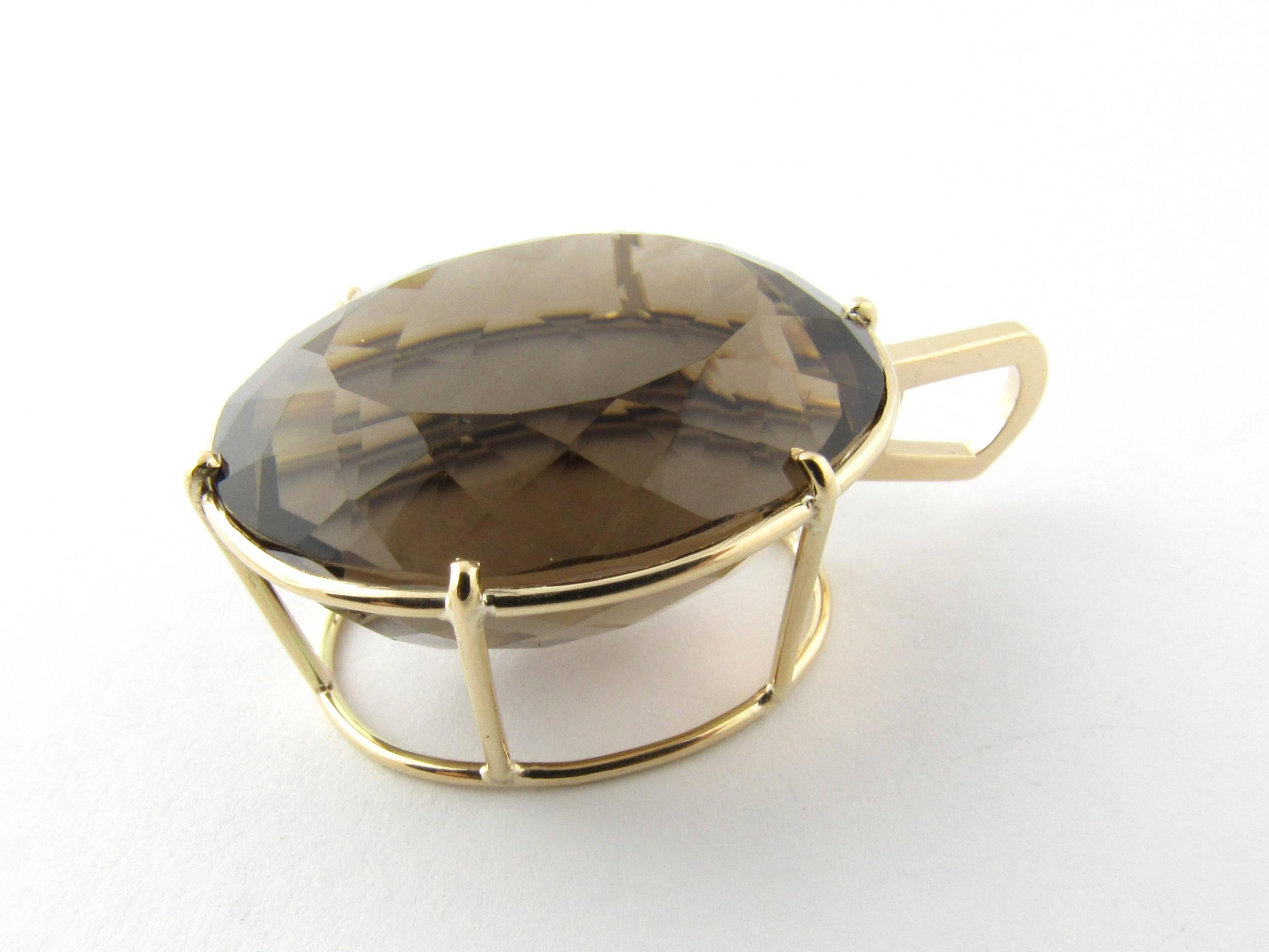 Vintage 14 Karat Yellow Gold Smoky Quartz Pendant
This fabulous pendant features a stunning oval smoky quartz 49.62 cts ( 25.4 x 21.8 x 15.9 mm ) set in beautifully detailed 14K yellow gold. Height: 16.5 mm. 
Smoky quartz is medium moderately strong