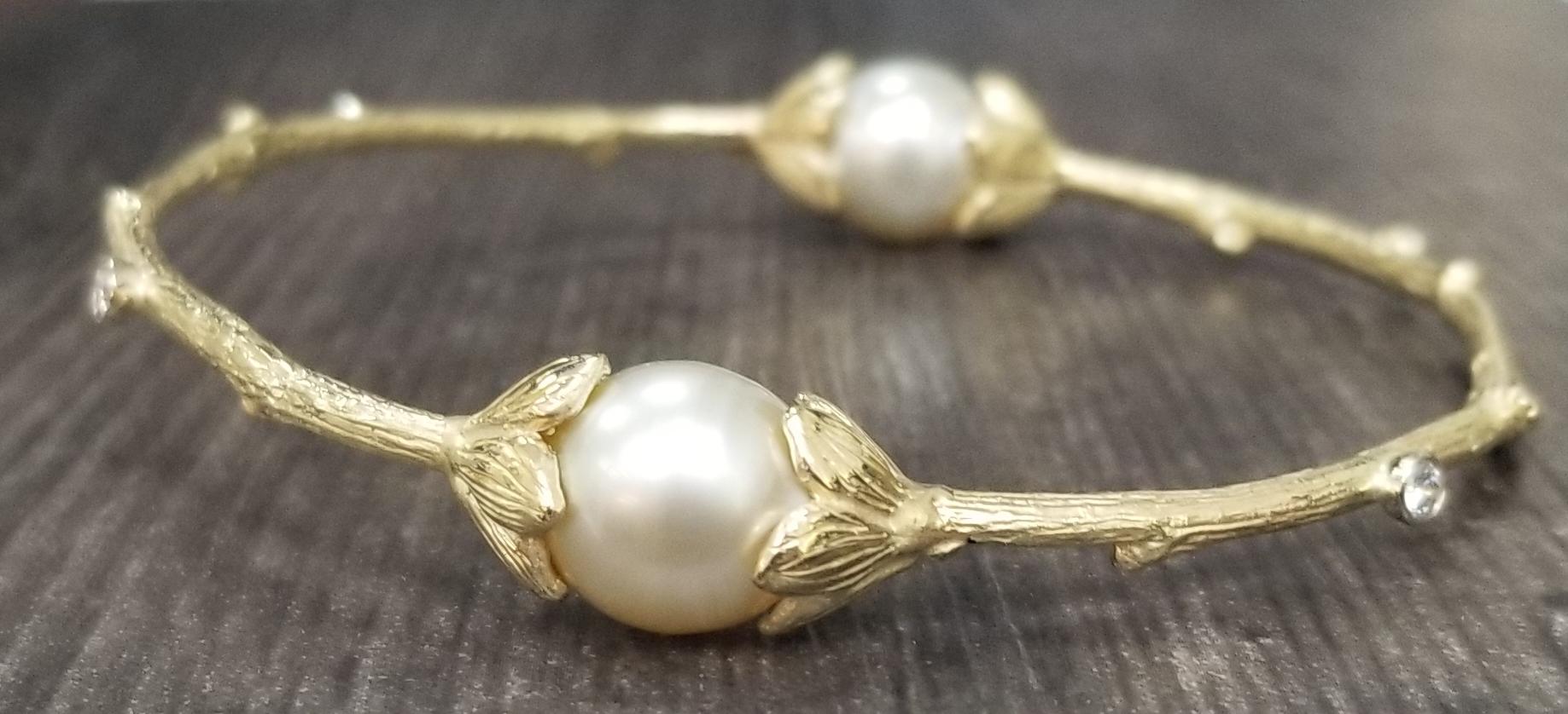 14k yellow gold Gresha signature bark bangle with 2 11mm south sea pearl and 4 round diamonds of fine quality weighing .36pts.  Get with other like bangles for stacking.
*this design is ours and can be created in any other form; ring, necklace,