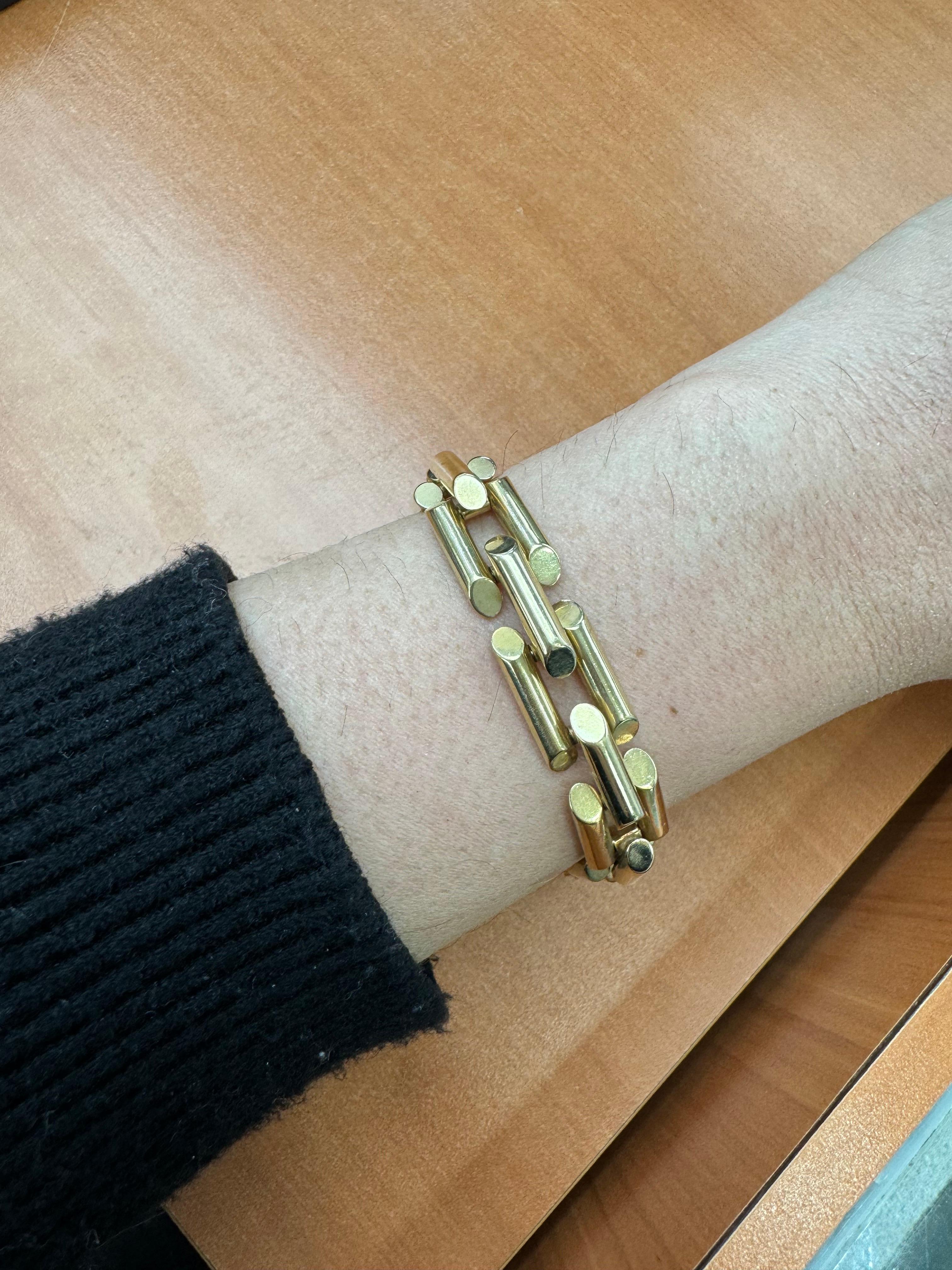 14 Karat Yellow Gold bracelet featuring three rows of a Tank motif link weighing 26 Grams. 
