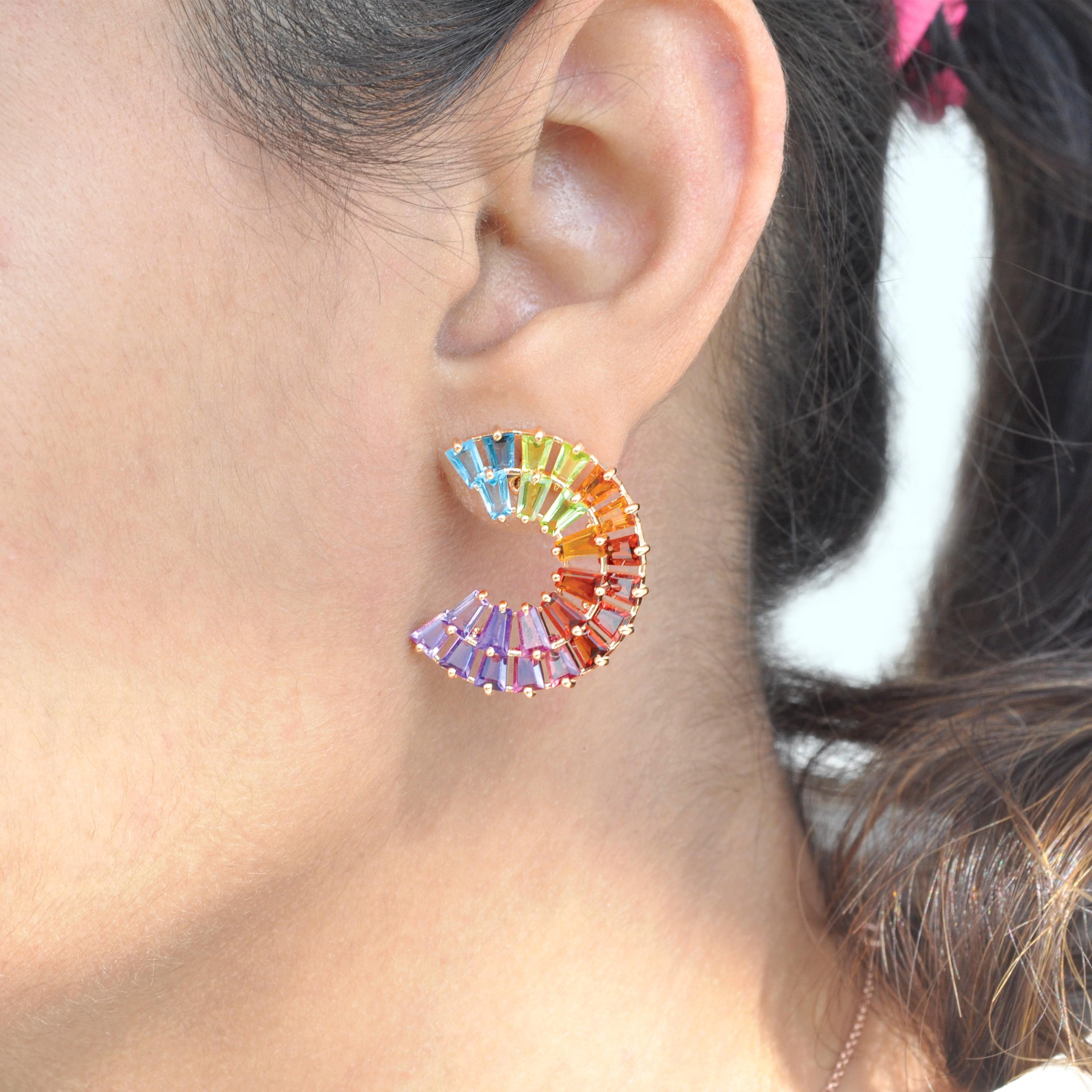 These stunning stud earrings are crafted in 14-karat yellow gold and adorned with an array of vibrant multicolor gemstones, offering a perfect blend of elegance and boldness. Each earring features 24 meticulously cut tapered baguette gemstones, each
