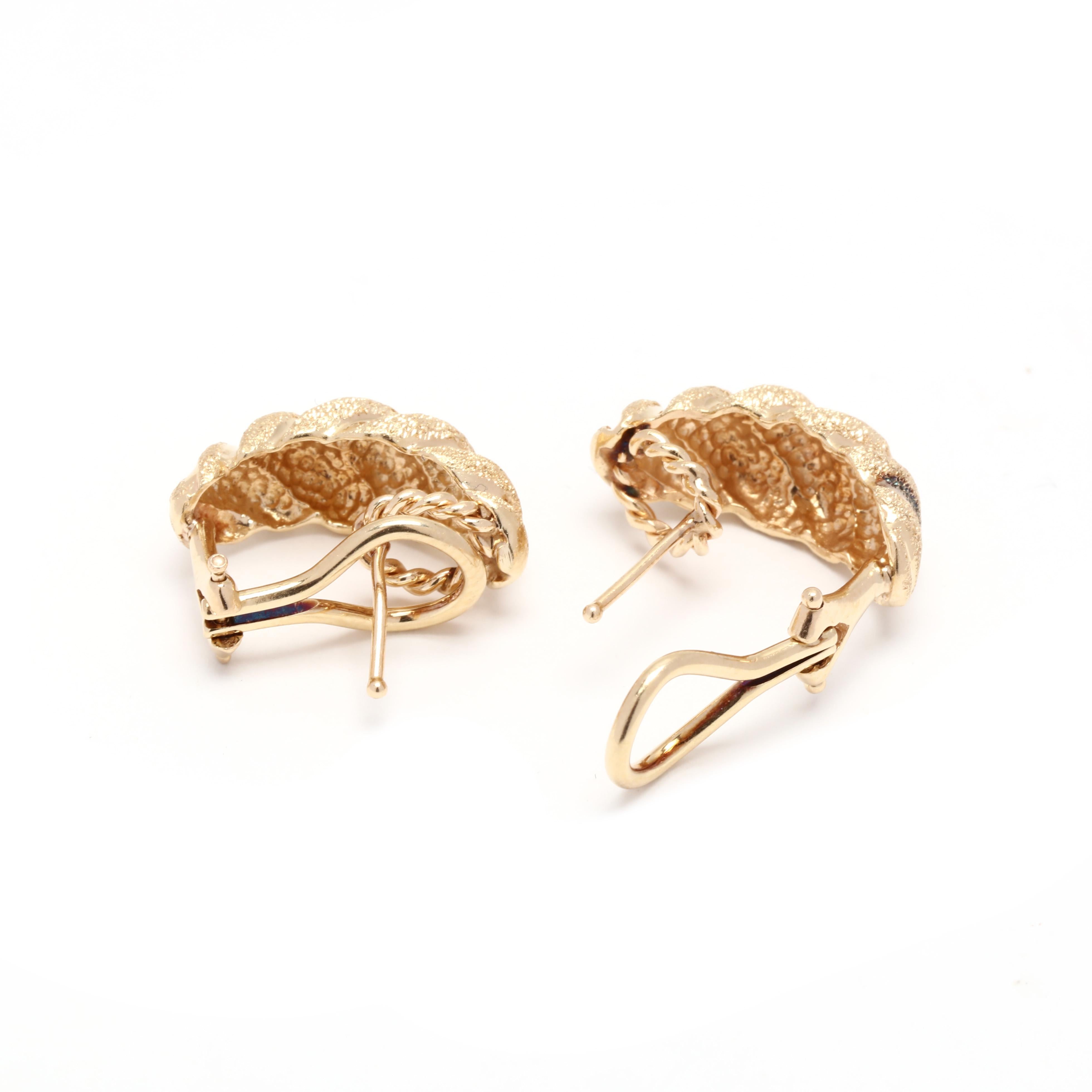A pair of 14 karat yellow gold textured shrimp hoop earrings. These earrings feature a croissant design with a stippled textured motif with pierced omega backs.



Length: 5/8 in.



Width: 5/16 in.



Weight: 4 dwts.
