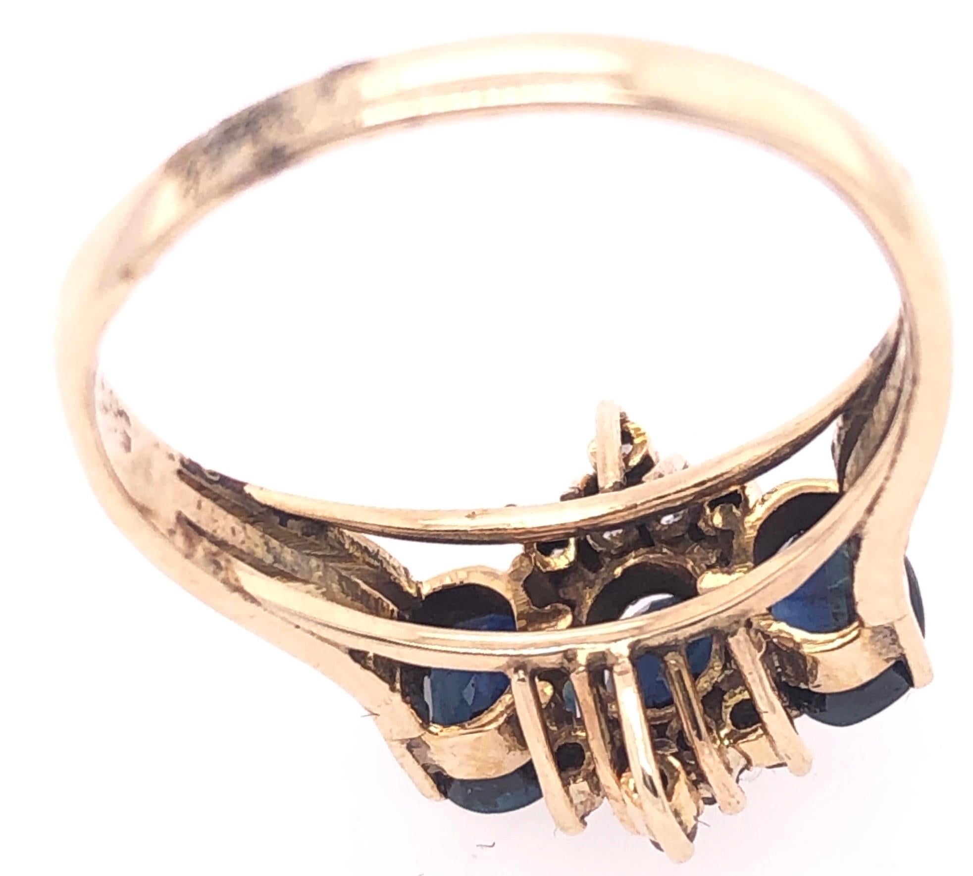 Modern 14 Karat Yellow Gold Three-Stone Sapphire Ring with Diamond Accents