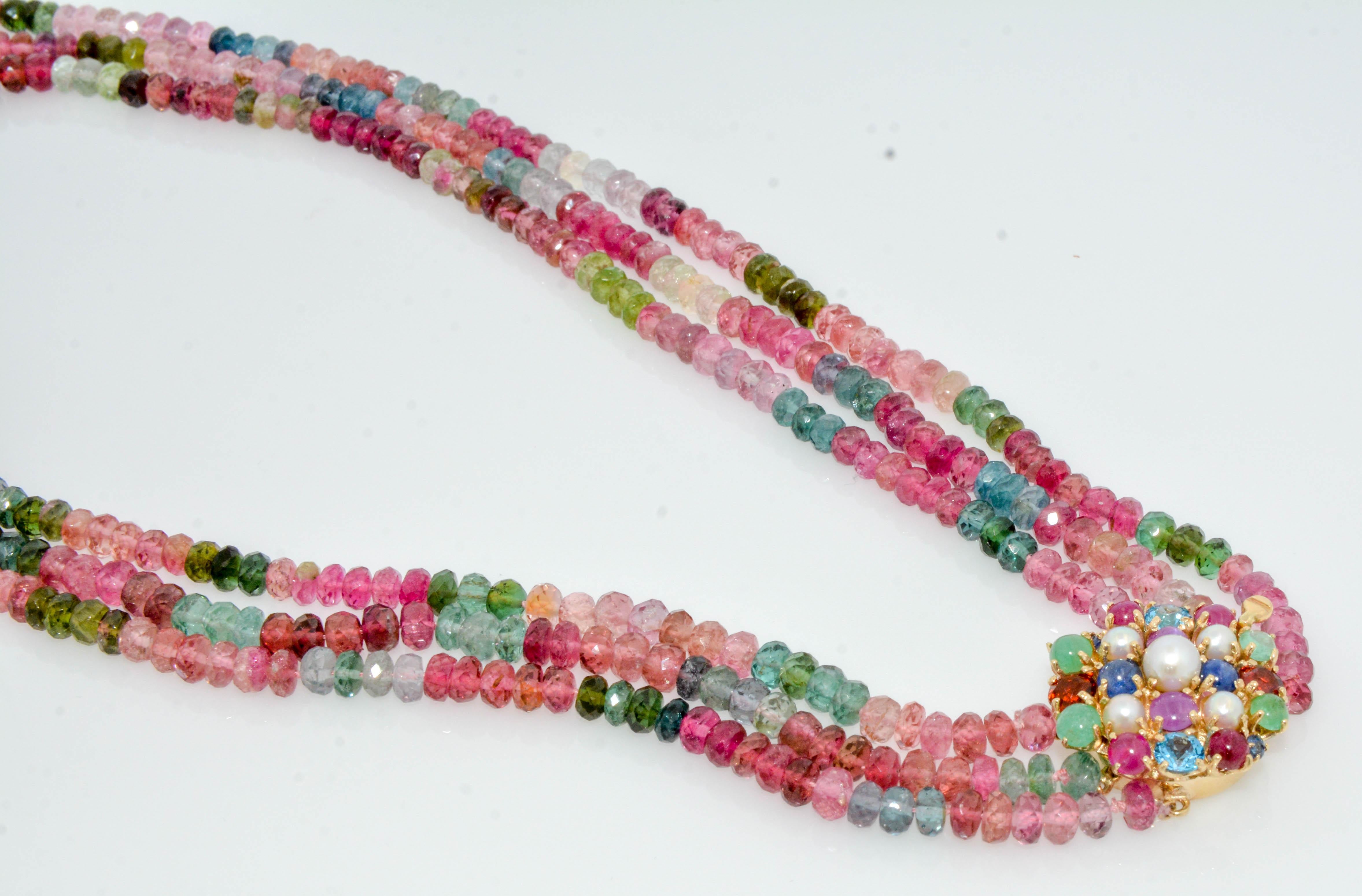 With a burst of color and zest; this tourmaline three strand bead necklace is a must-have! Make a colorful statement with a gemstone clasp set in two round blue sapphires (0.10ctw), two blue topaz (0.70ctw), four cabochon rubies (1.20ctw), four