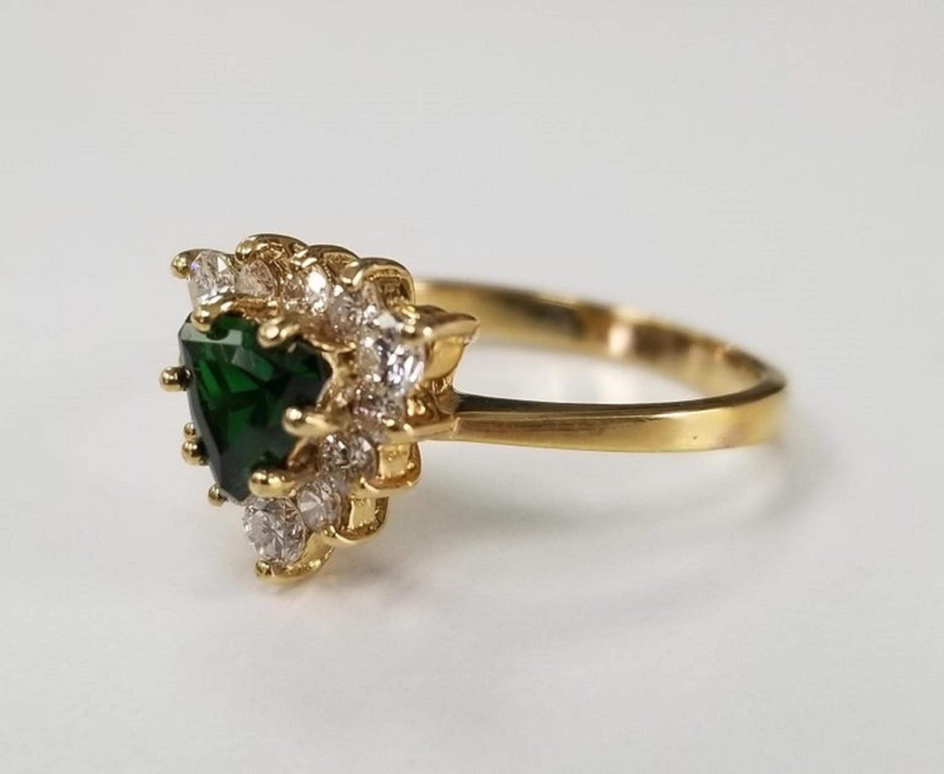 14k yellow gold tsavorite and diamond ring, containing 1 trillion cut  tsavorite weighing .87pts. and 12 round full cut diamonds of very fine quality weighing .55pts.  This ring is a size 6 but we will size to fit for free.

Tsavorite is a trade