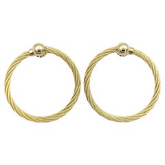 Pendientes perforados de aro en oro amarillo de 14 quilates con diseño de cable trenzado mirando al frente