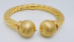 14 Karat Yellow Gold Twisted Hollow Ball Bangle, 18.6 Grams, Spring Hinge