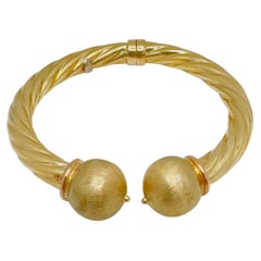 14 Karat Yellow Gold Twisted Hollow Ball Bangle, 18.6 Grams, Spring Hinge