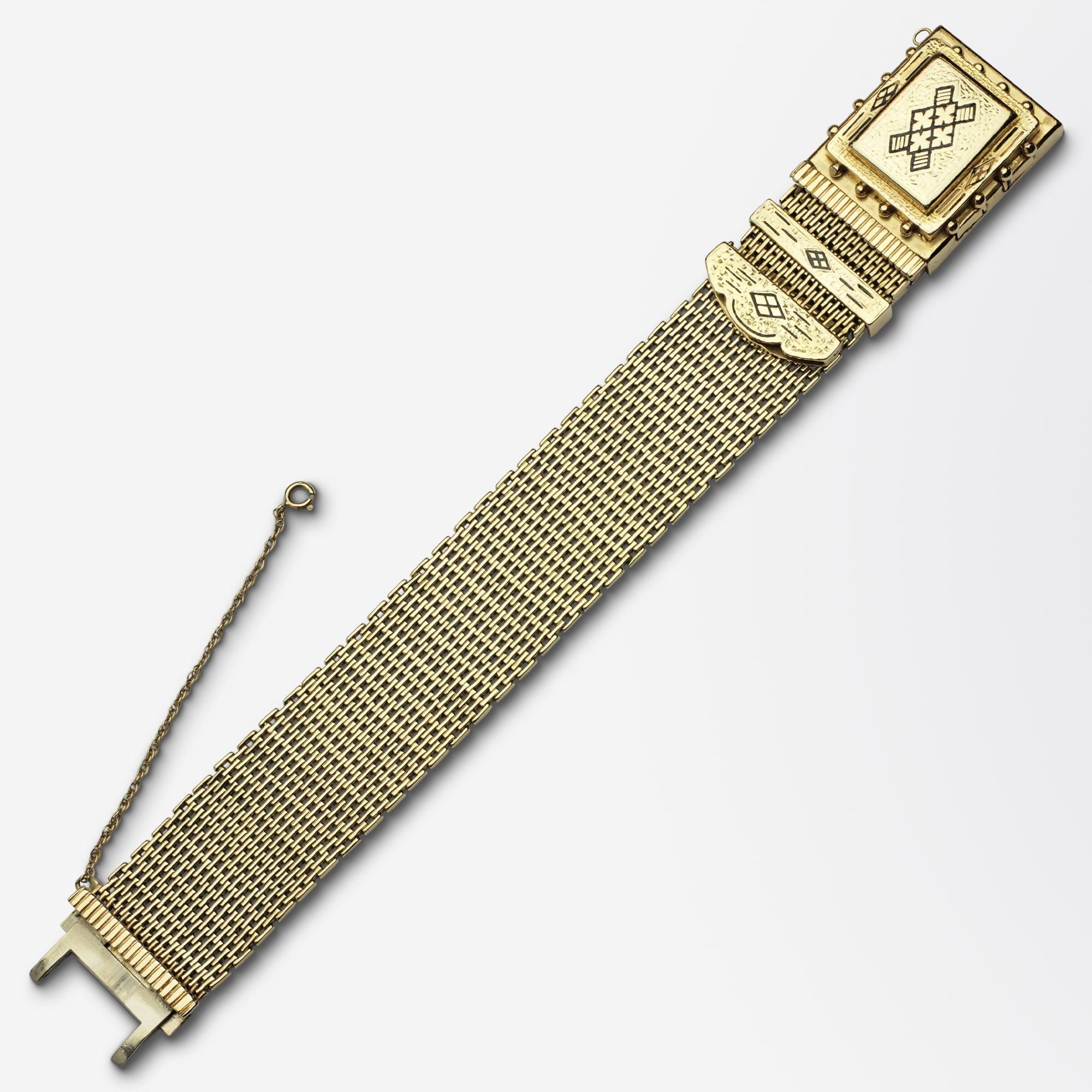 An unusual 14 karat yellow gold bracelet in the Victorian taste with delicate black enamelling. The small bar riveted style bracelet has a hinged lid centre box with black enamelled inlay as a feature with scalloped end cap and slide which form a