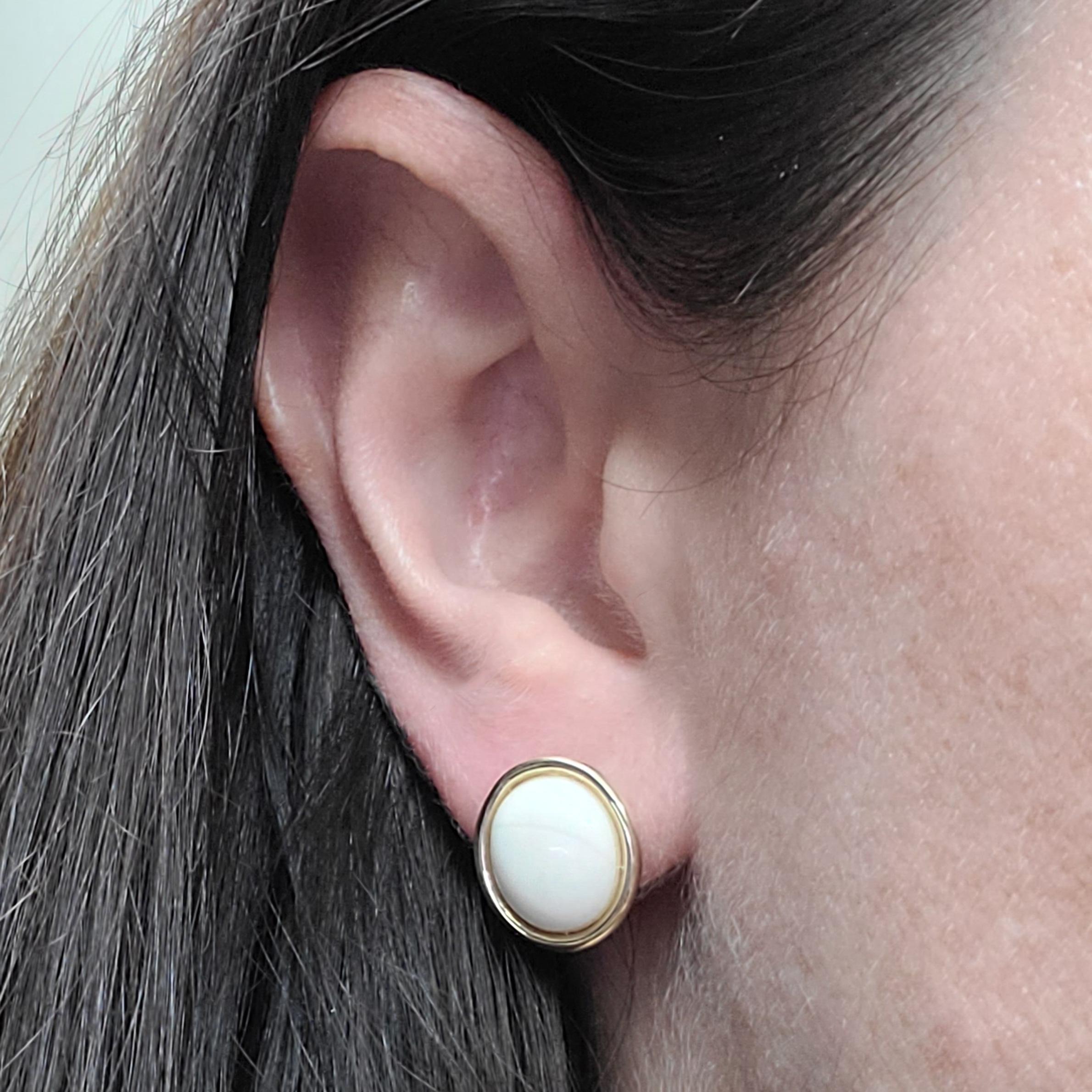 14 Karat Yellow Gold Stud Earrings Featuring Bezel-set Oval White Coral Cabochons. Friction Post with Pushback Nut. Finished Weight is 2.0 Grams.