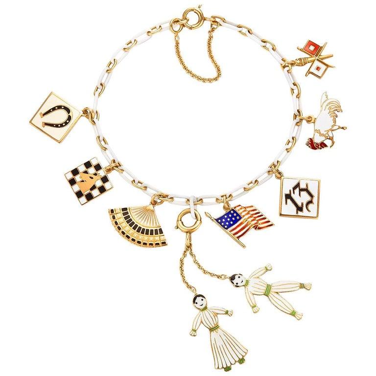 Comprising eight enamel charms stamped 14K, the charms include a horseshoe plaque, a chess board, a fan, a pair of dolls, an American flag, a lucky 13, a rooster, and a pair of flags, 7x1/2x2   

Signed Cartier
