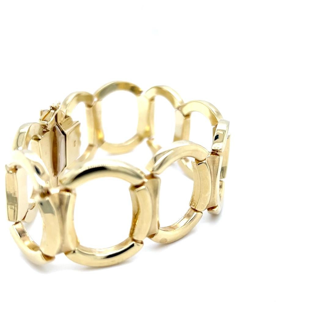 One 14 karat yellow gold 27.5mm wide open oval link bracelet measuring  7.75 inches long.  The bracelet features high polished oval links and hinged links and grooved center section with a satin finish.  The bracelet is complete with a hidden box