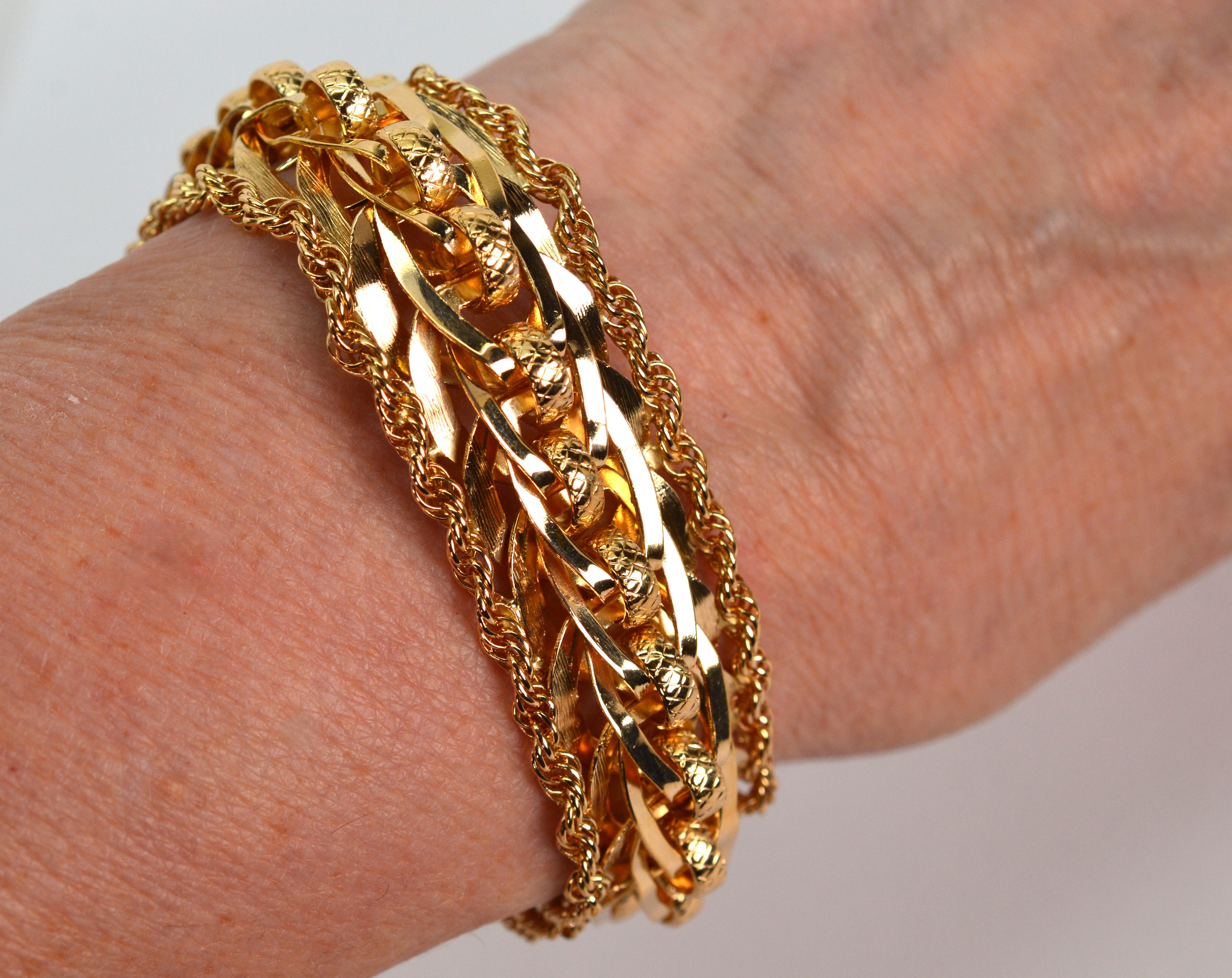 Ce bracelet de style rétro est composé de maillons d'or jaune 14 carats inspirés de rubans brillants. D'une présentation audacieuse, les maillons circulaires en or entrelacés sont tissés ensemble dans un motif ouvert. Les bords sont joliment garnis
