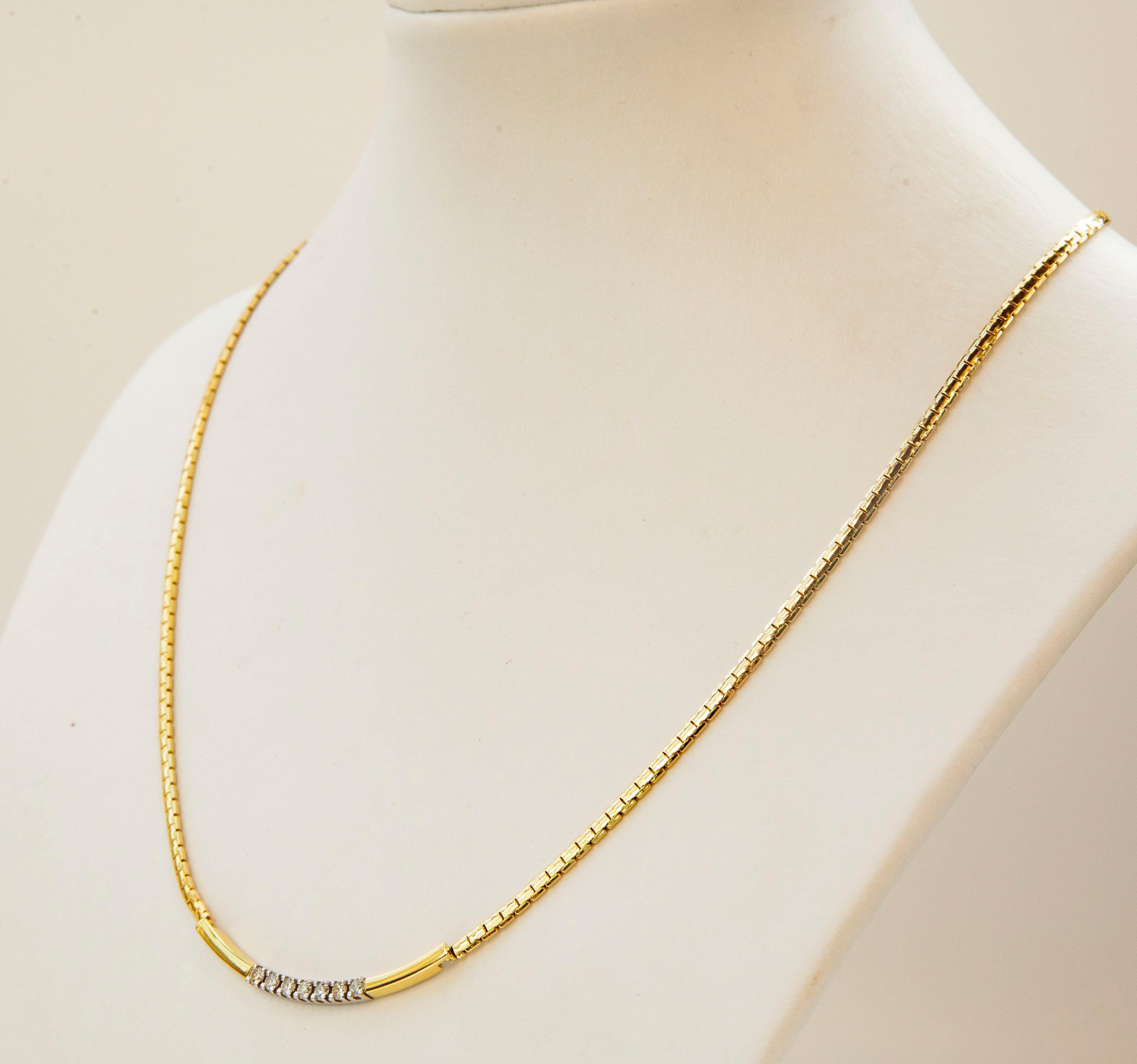 A vintage flat snake necklace made of 14 karat yellow solid gold. The necklace features a central bicolor (white and yellow gold) curved insert set with seven brilliant cut diamonds.  The necklace closes with a spring ring clasp.

It would be a
