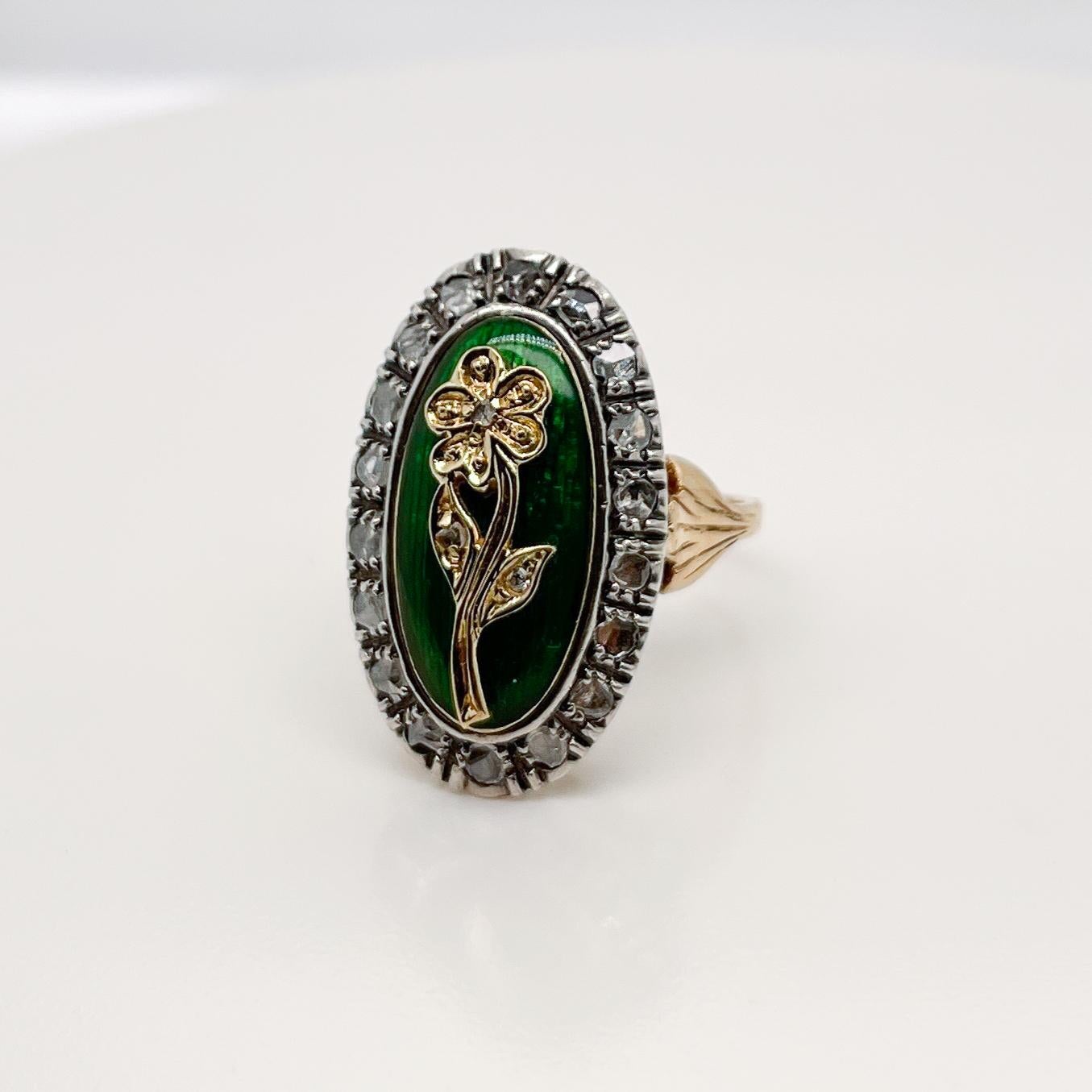 A very fine vintage enamel cocktail ring.

In 14k gold with a gold flower on green guilloche enamel cushion. 

The gold flower is set with small accent rose cut accent diamonds, and the entire head is framed in halo of rose cut diamonds. 

The base