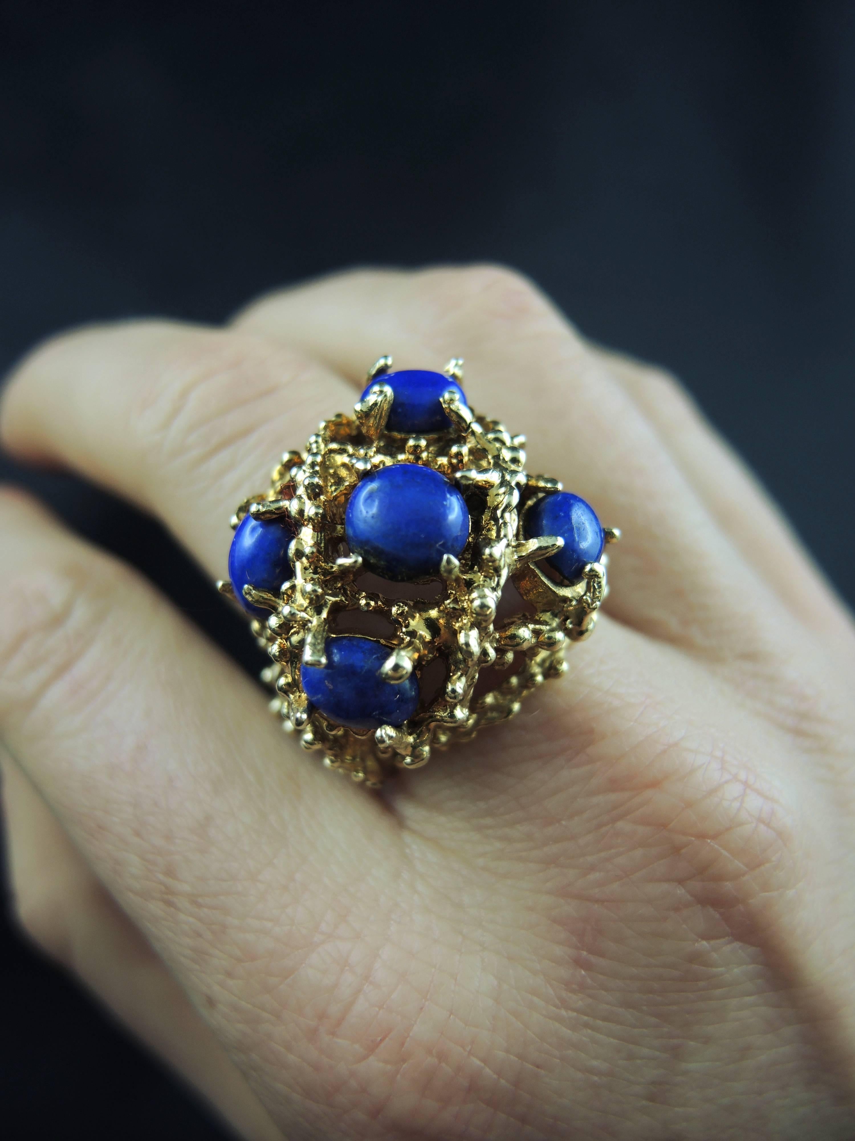 14kt yellow gold cocktail ring (quality mark: scallop) set with 5 lapis lazuli cabochons.

Work from the 70ies.

Weight: 21.90 g
Ring size: 54 (diameter 17,20/ US size 6.75).

State : very little scratches on the gold parts, visible on the pictures.