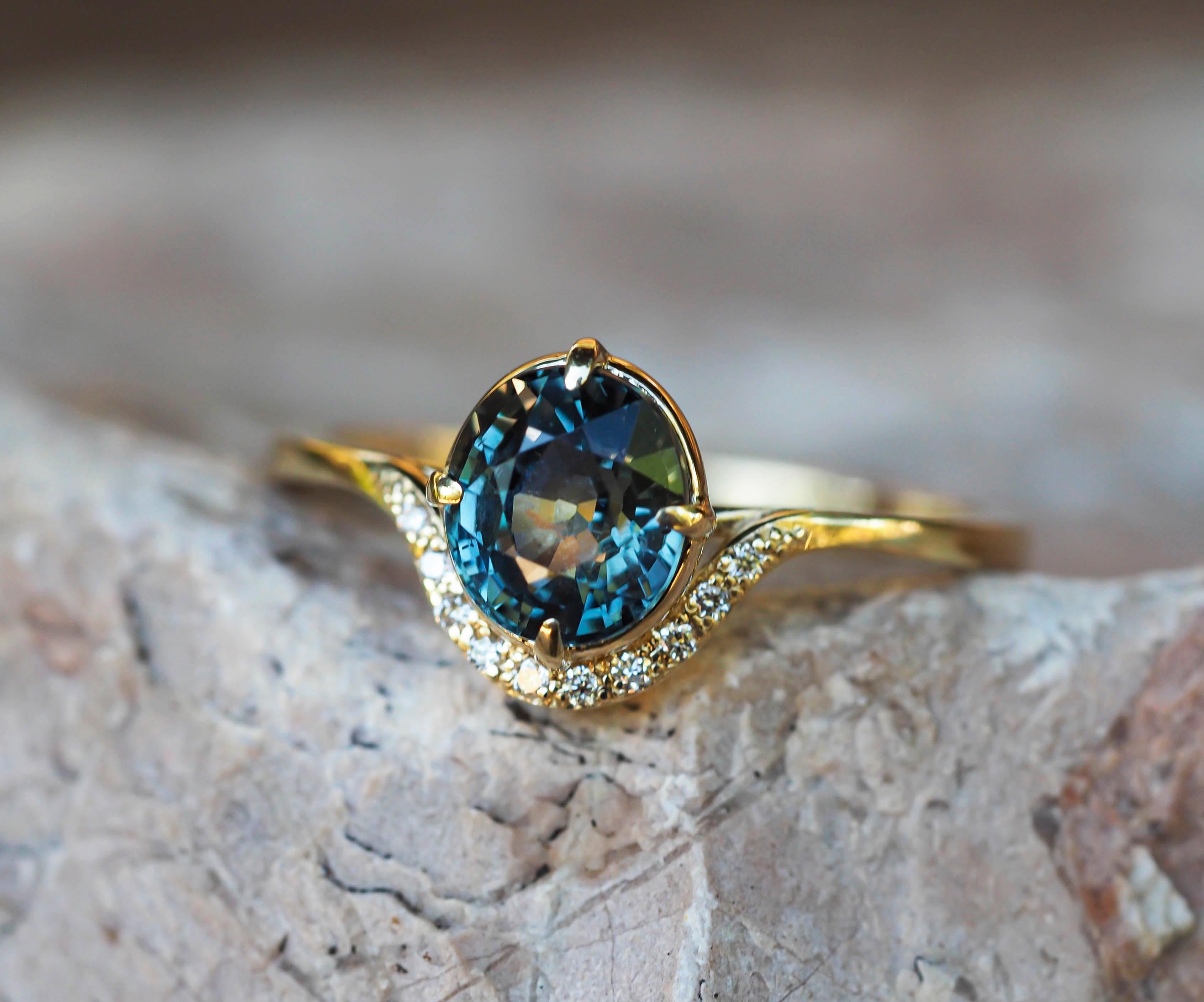 14 kt gold ring with sapphire and diamonds.
Weight: 2.00 g.

Set with sapphire, color - bluish, yellowish green
oval cut, aprox 1.2 ct
Clarity: Transparent with inclusions
Surrounding stones: 10 diamond 0.01x10=0.10 ct (F/VS), round brilliant cut.
