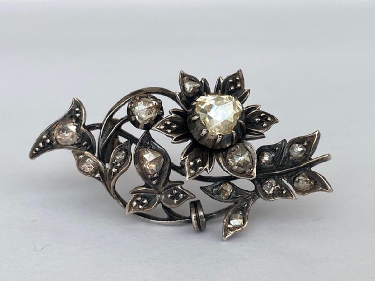 This magnificent antique brooch is in 14k yellow gold and silver. The brooch is set with a large rose-cut diamond of approx. 0.80 ct (a modern brilliant cut diamond of this size would have an estimated weight of approx. 0.80 ct. and 14 rose cut